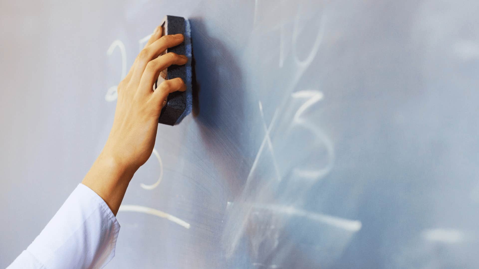 student cleaning chalkboard