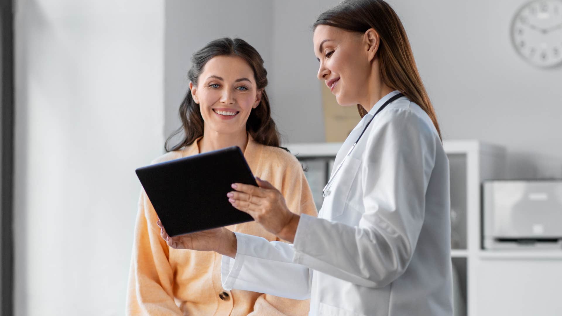 Gen Z woman smiling next to her doctor