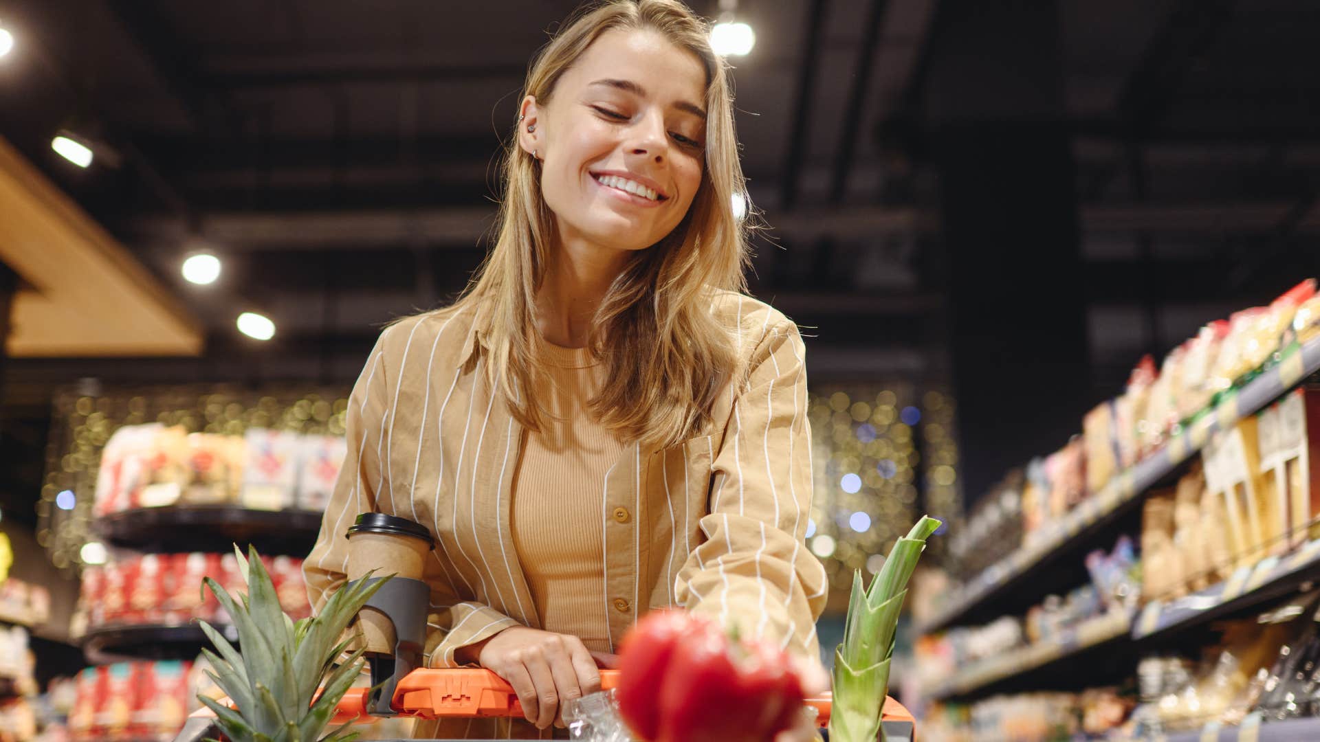 Gen Z woman smiling and shopping at a premium grocery store