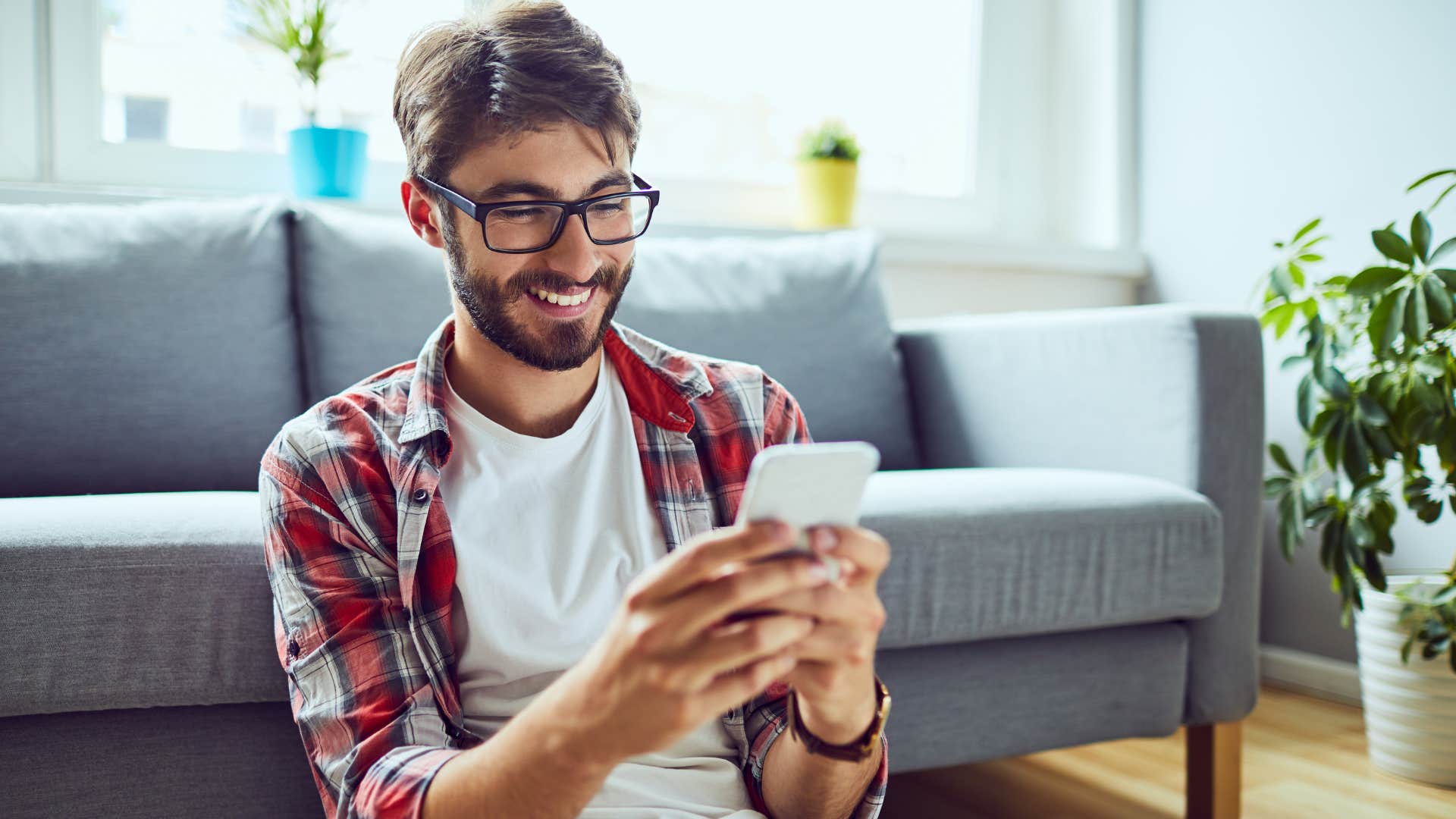 Gen Z man sitting on the floor in his curated living space