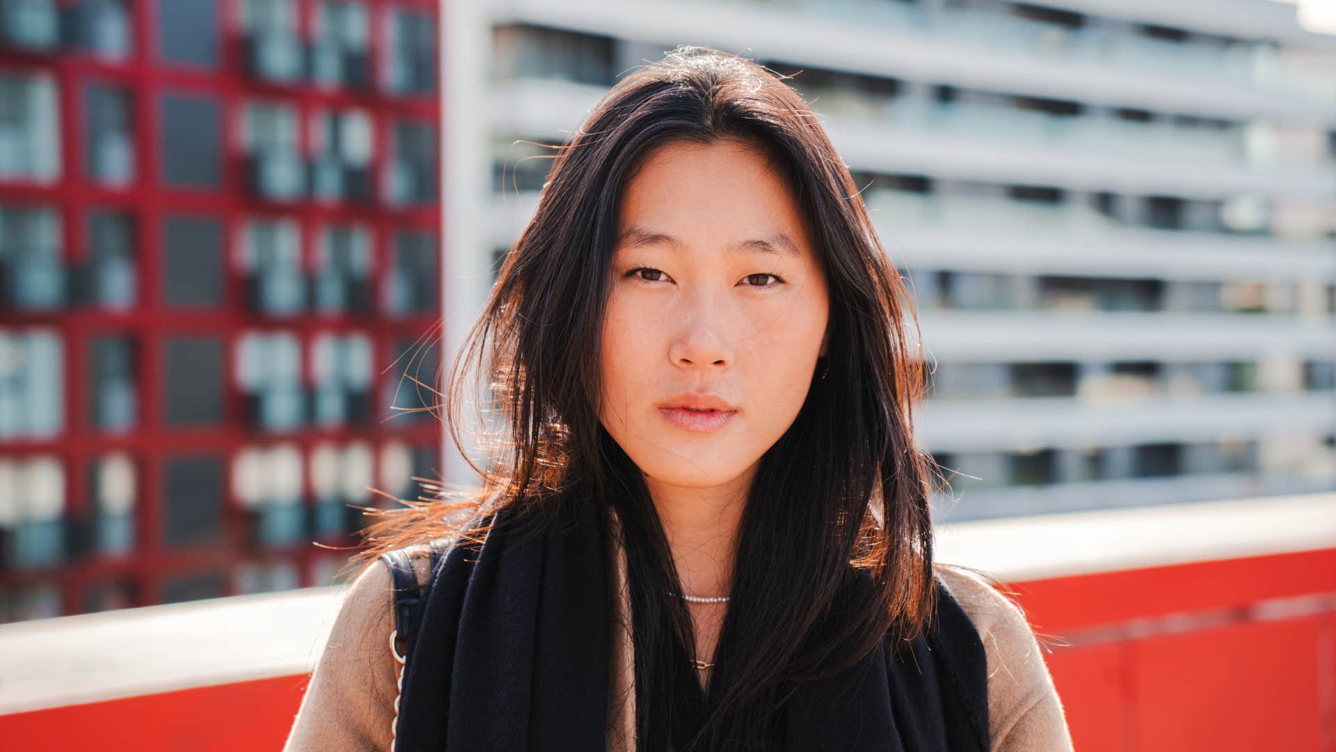 serious Gen Z woman standing outside on roof of building