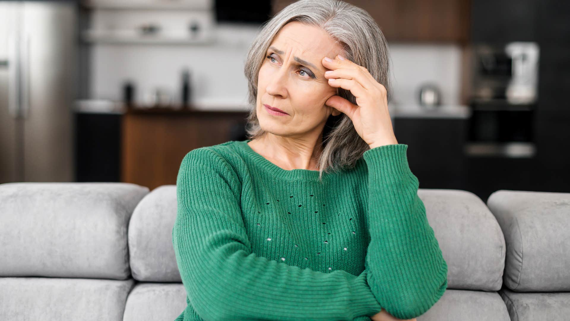 annoyed woman holding her head in her hands