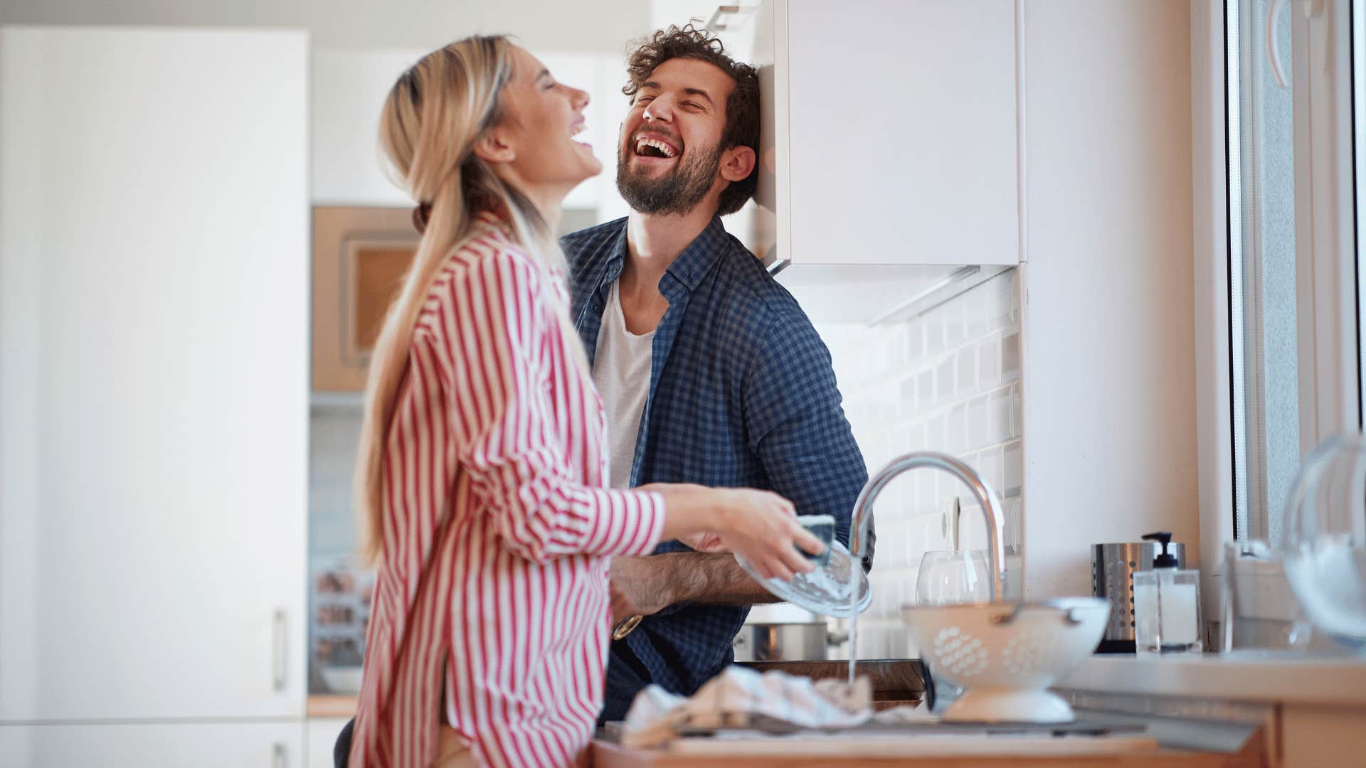 husband and wife laughing in the kitchen