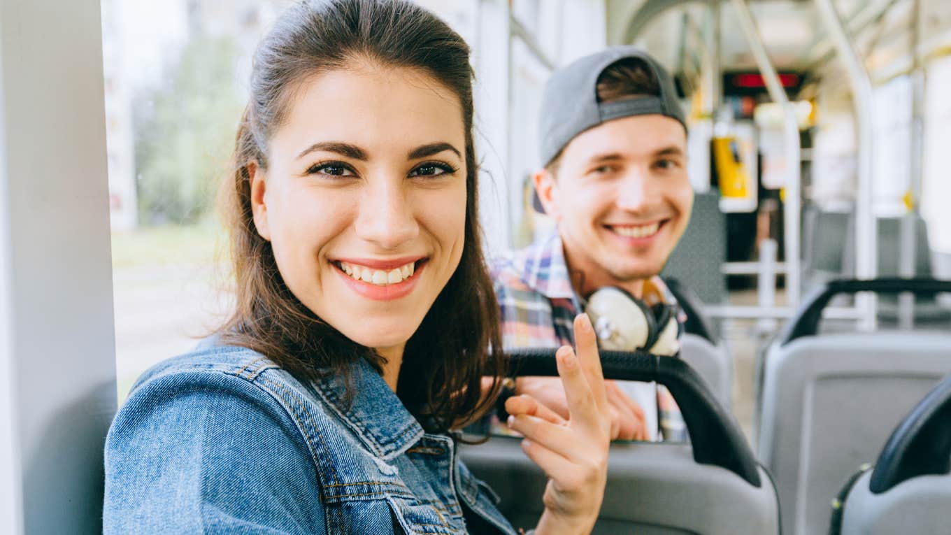 woman sits on the bus with her husband smiling