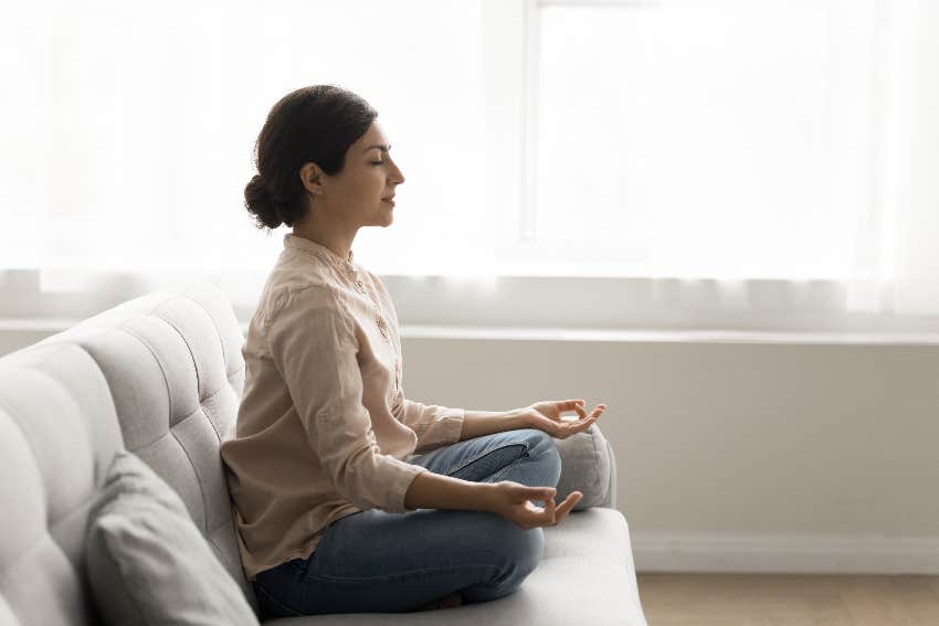 woman meditating on couch