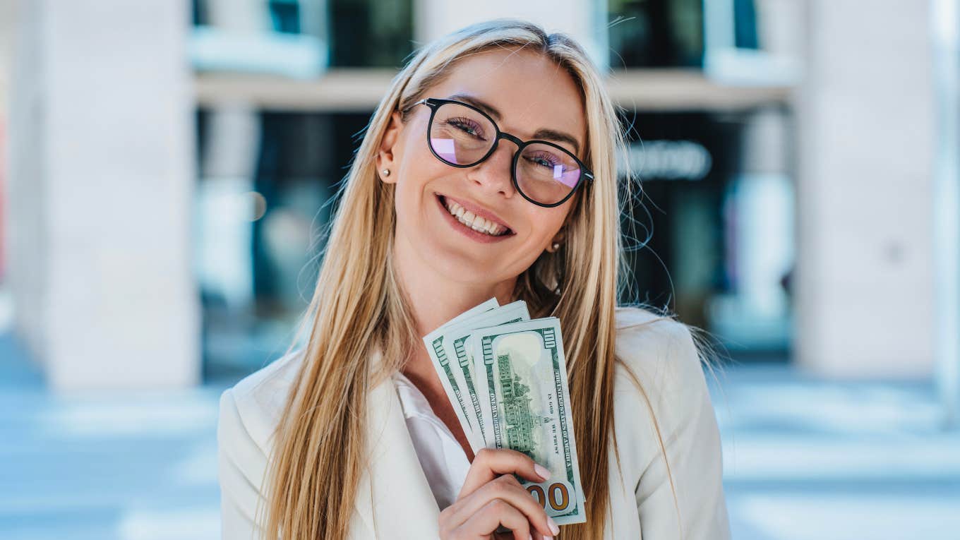 financially responsible woman smiling holding cash