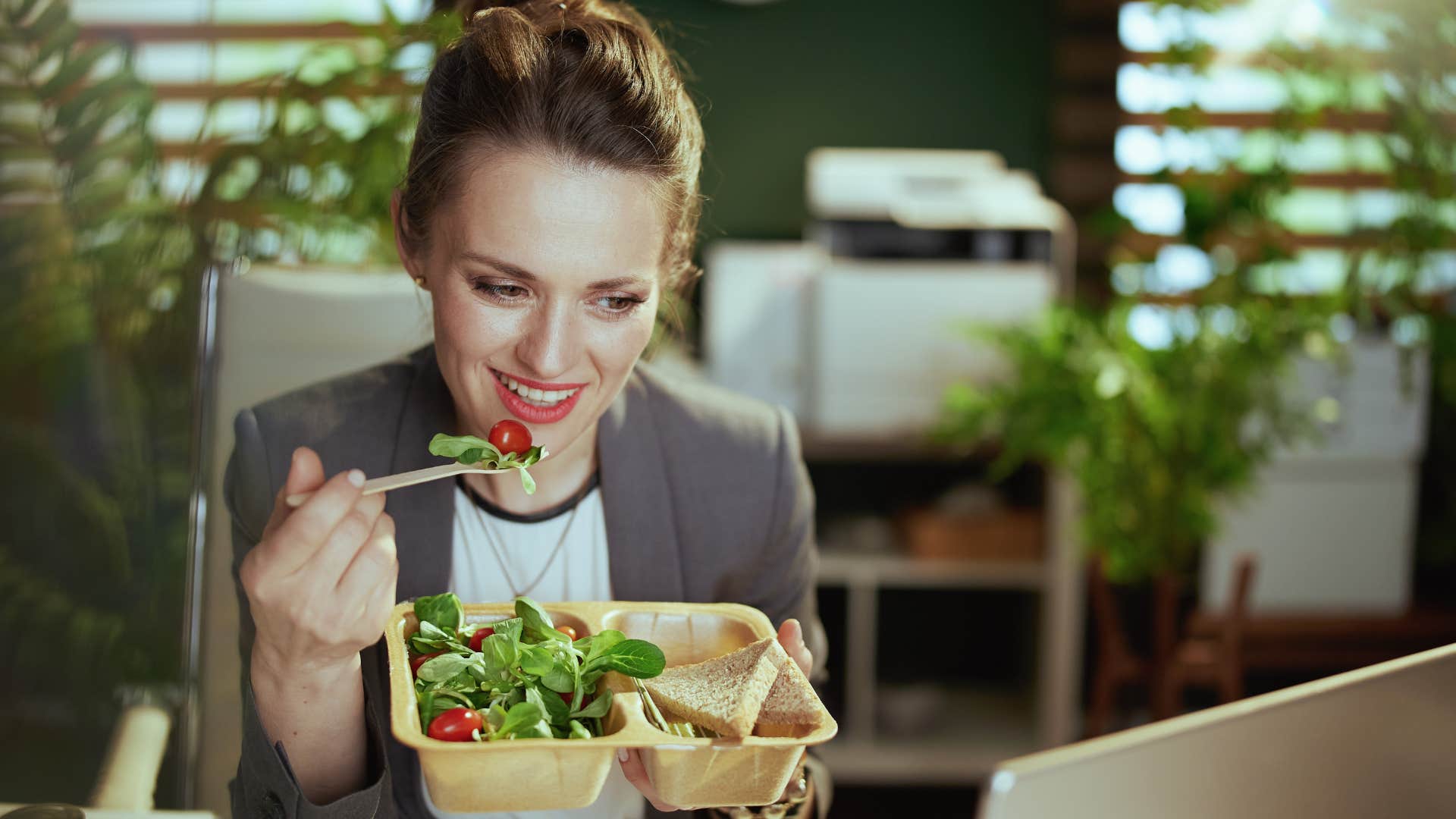 woman eating a salad at her desk