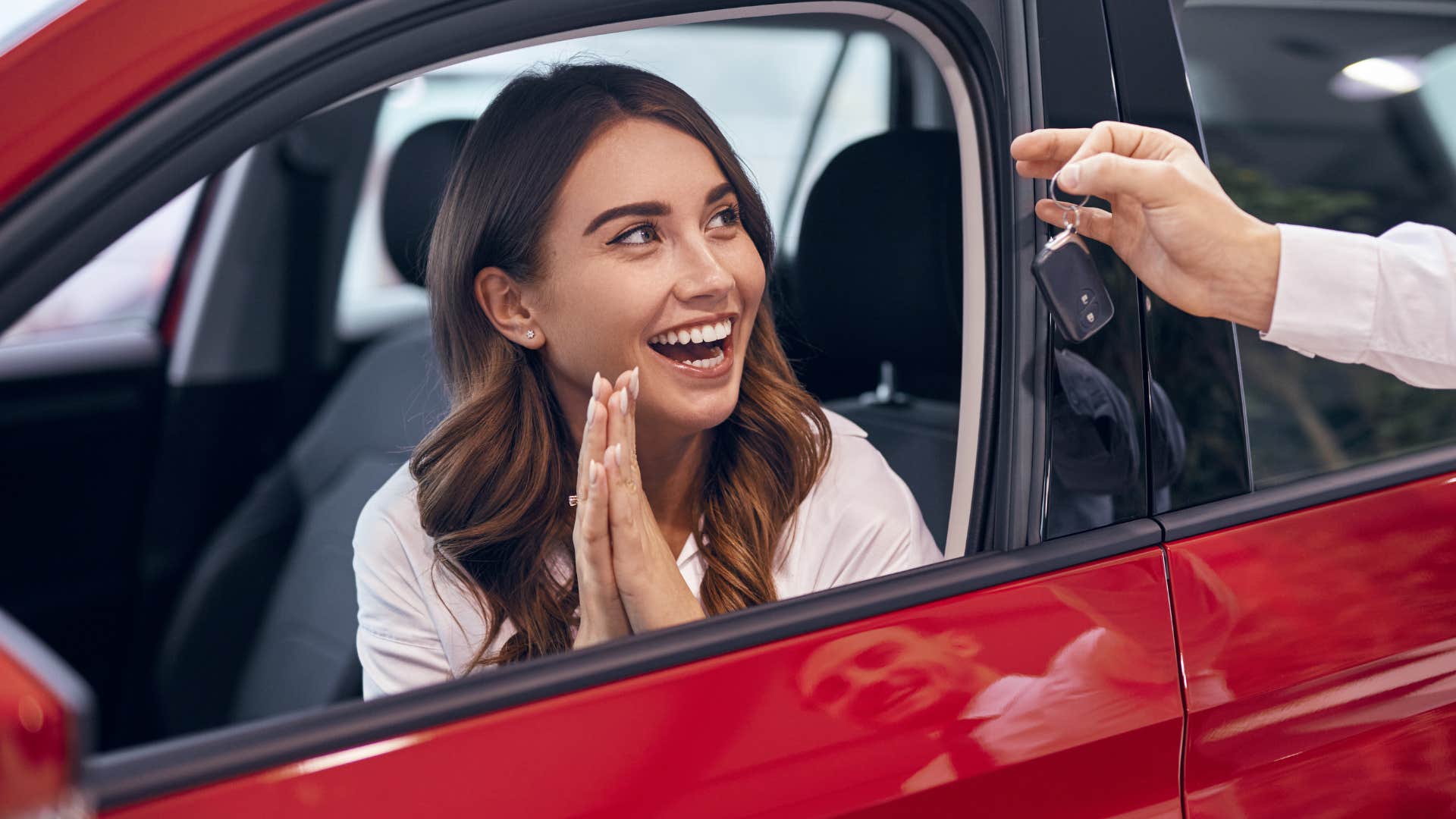 woman smiling being handed a car key