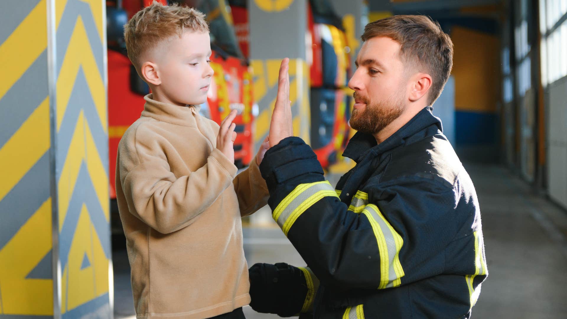 firefighter high-fiving little boy