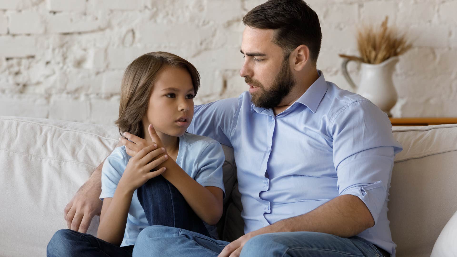 dad comforting young son holding his hand