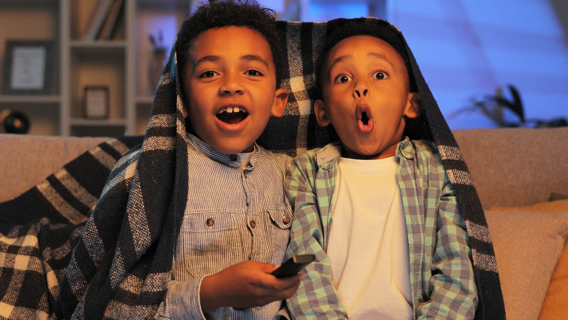 two little boys looking shocked watching TV