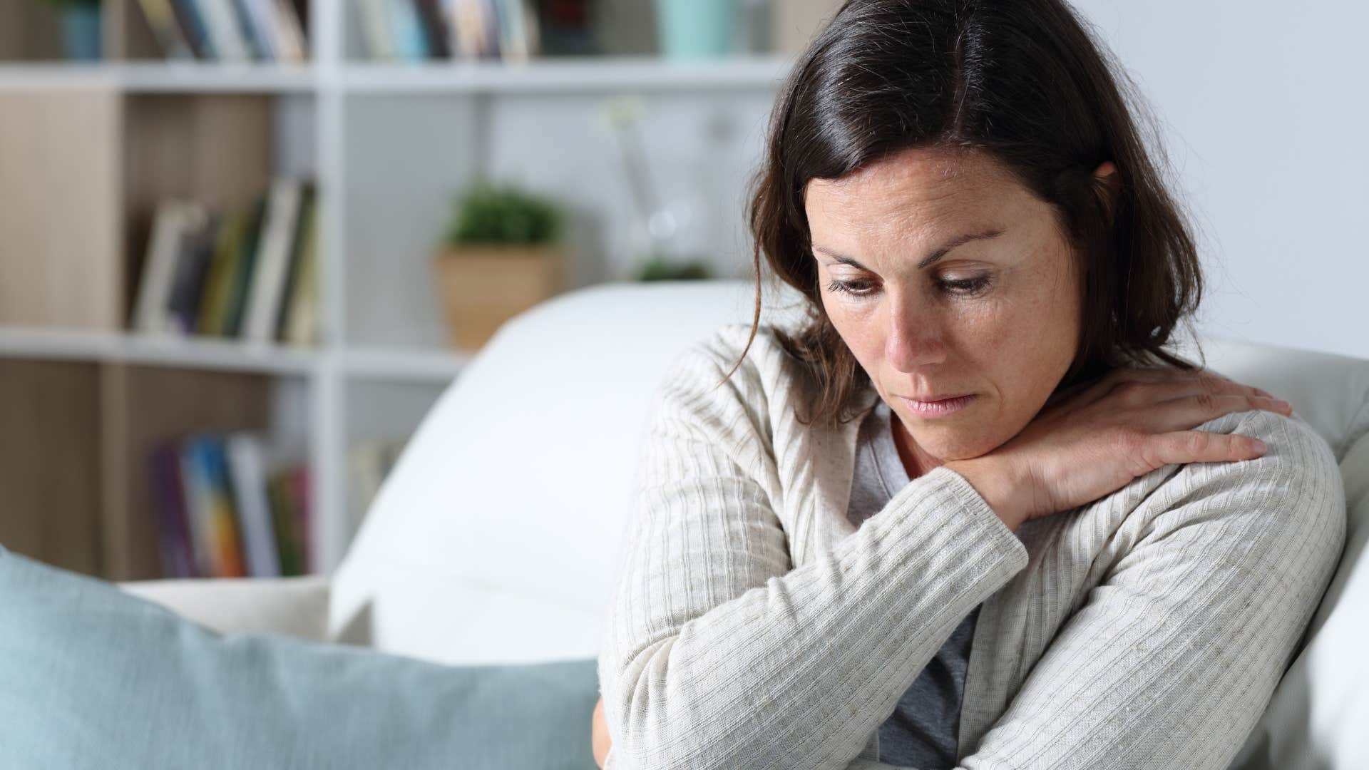 unhappy woman sitting alone on her couch