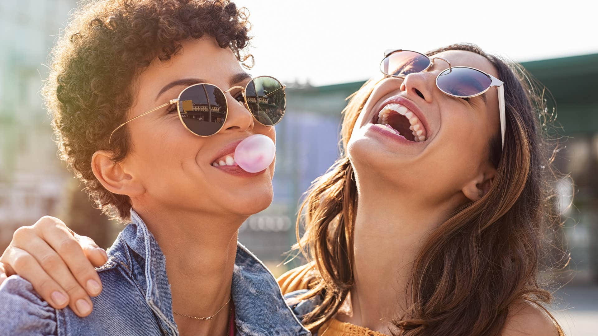 two women smiling and chewing gum