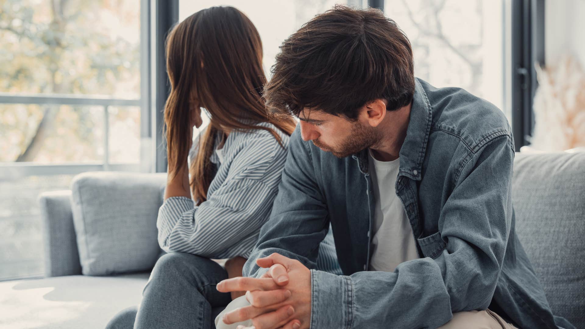 man and woman arguing on couch