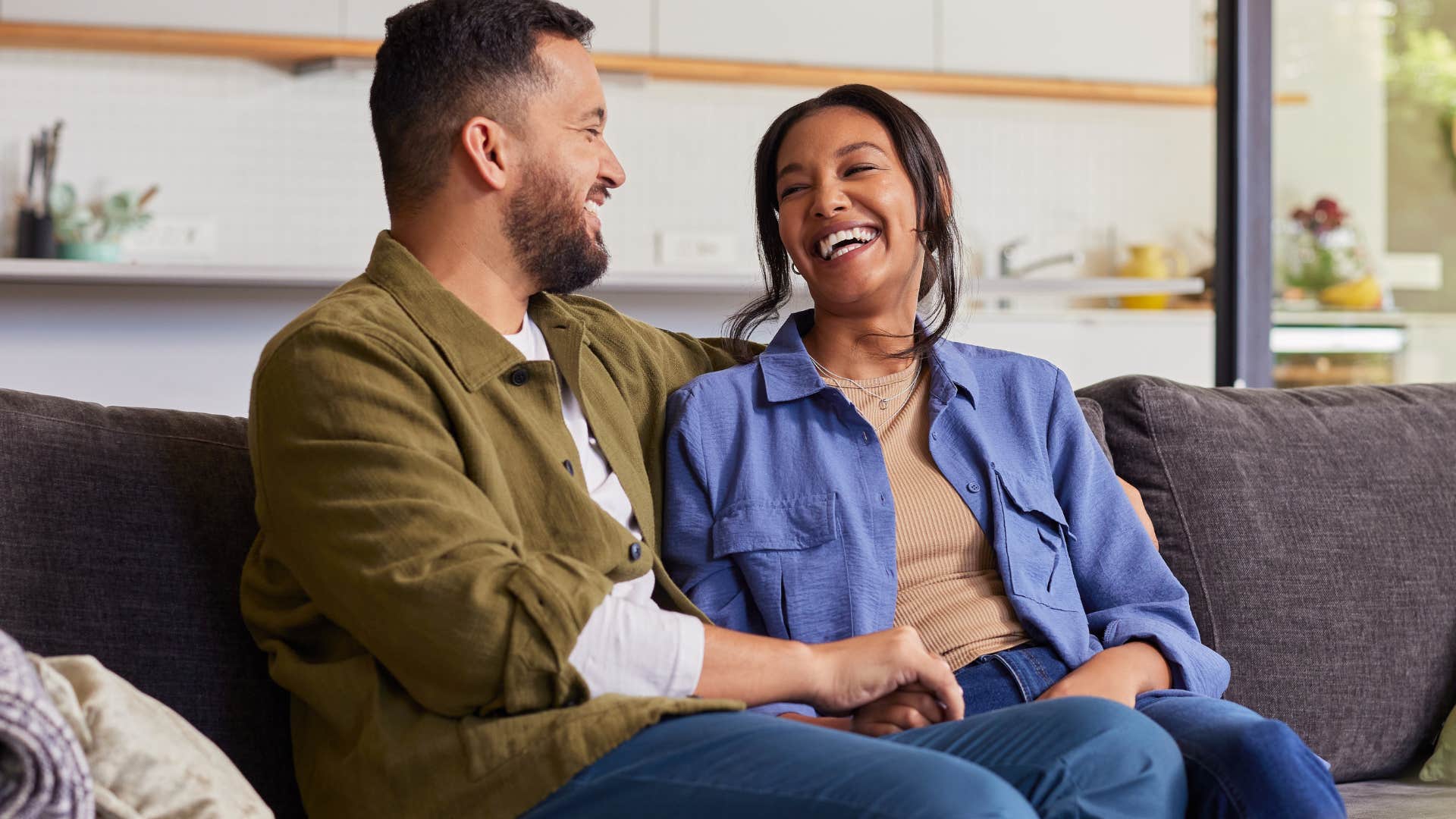 couple smiling sitting on a couch