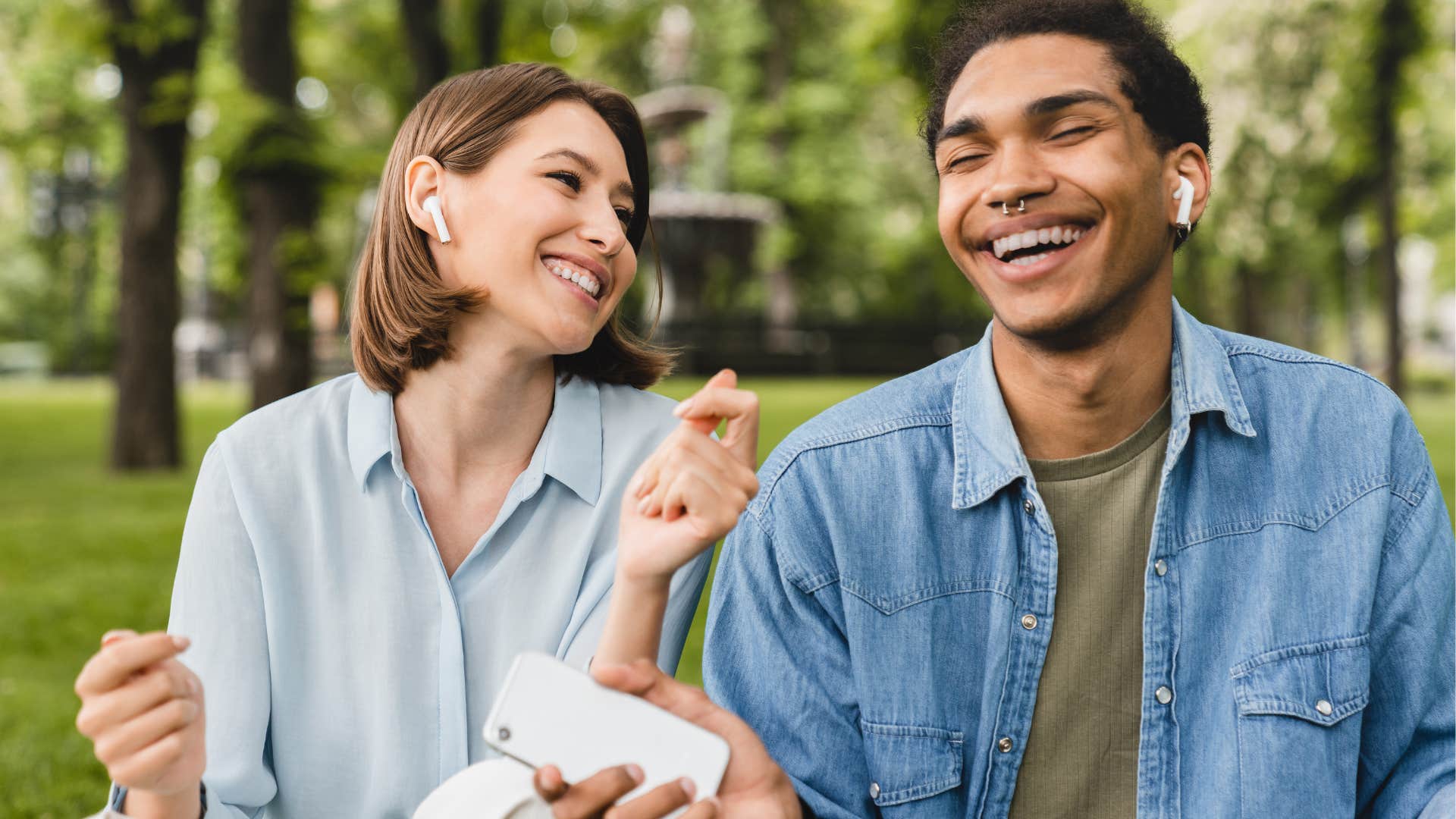 man and woman smiling listening to music