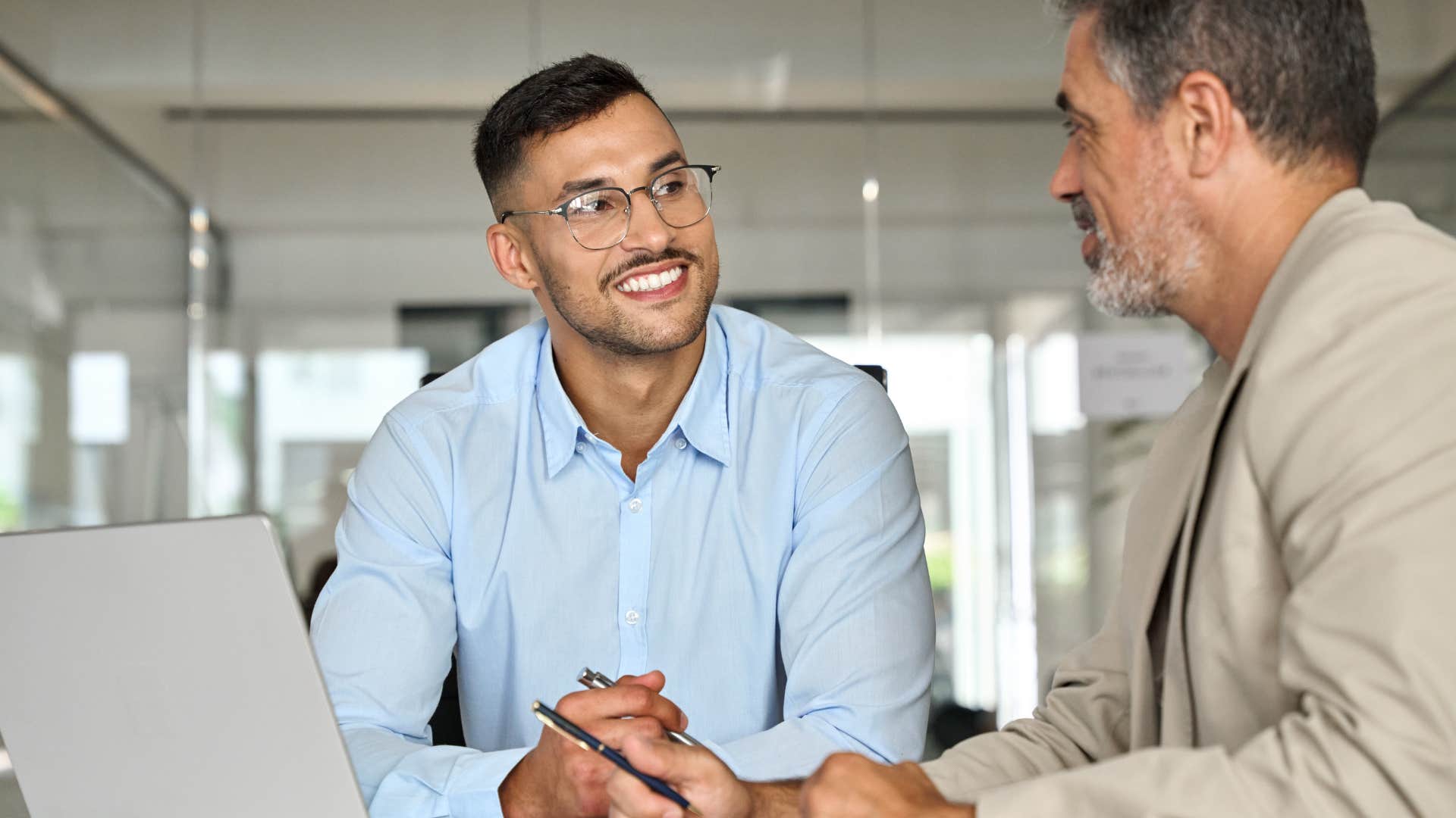 professional man smiling and talking to his peer