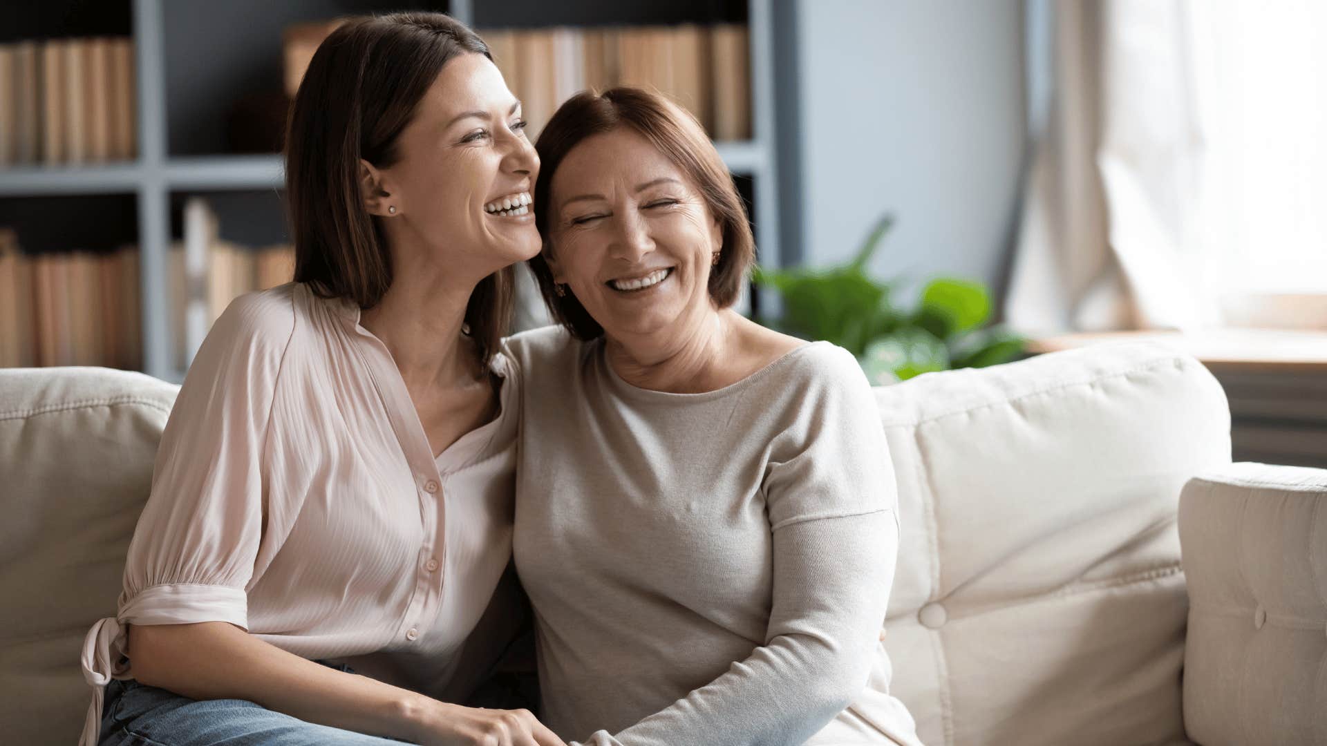 younger woman hugging older woman on couch