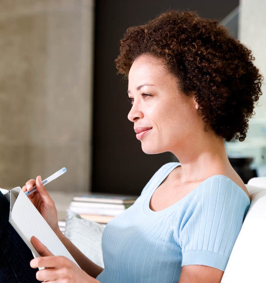 Woman happily writing in her journal