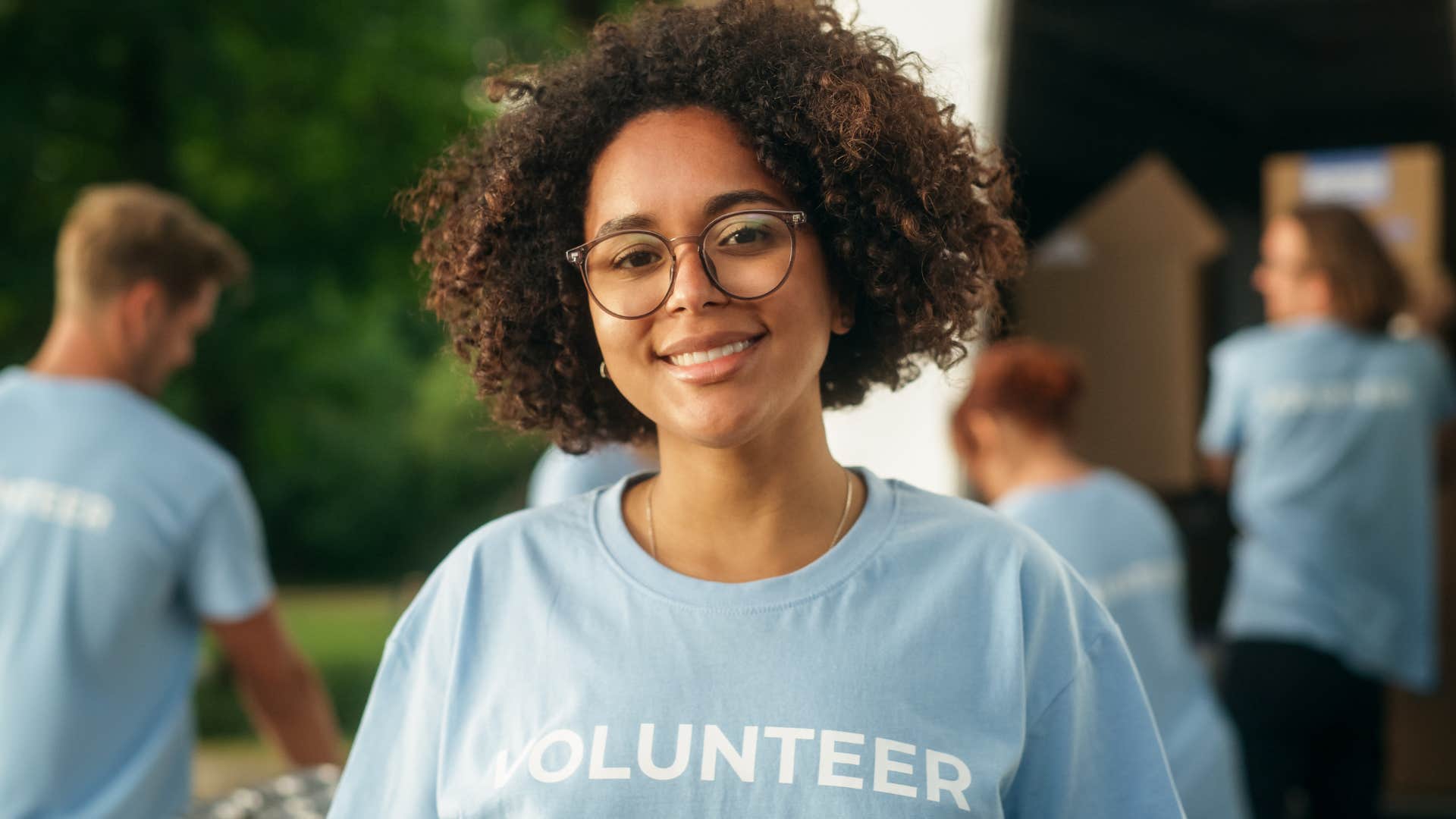 high value woman smiling while volunteering with other people