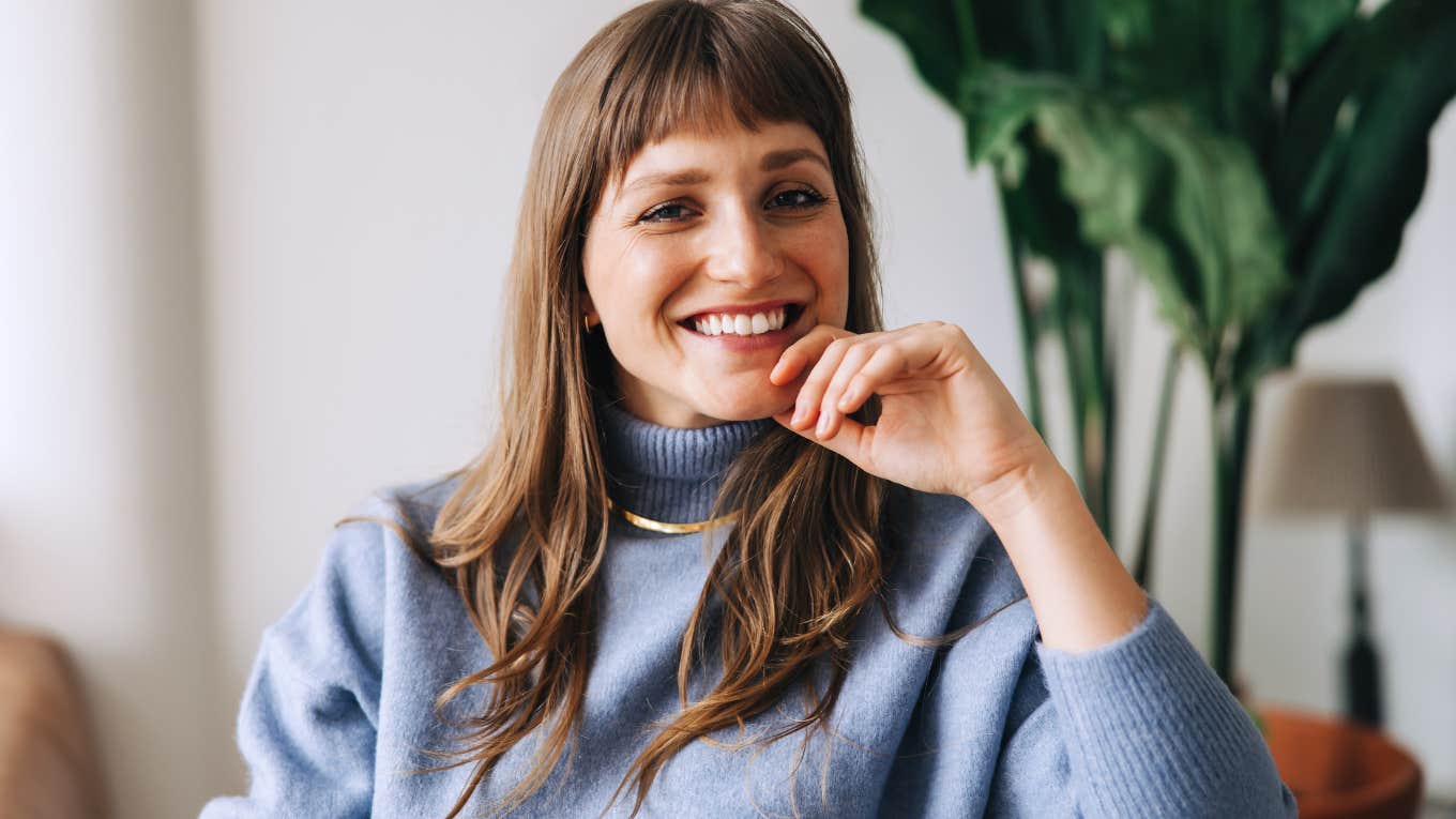 Woman smiling and holding her chin in her hands.