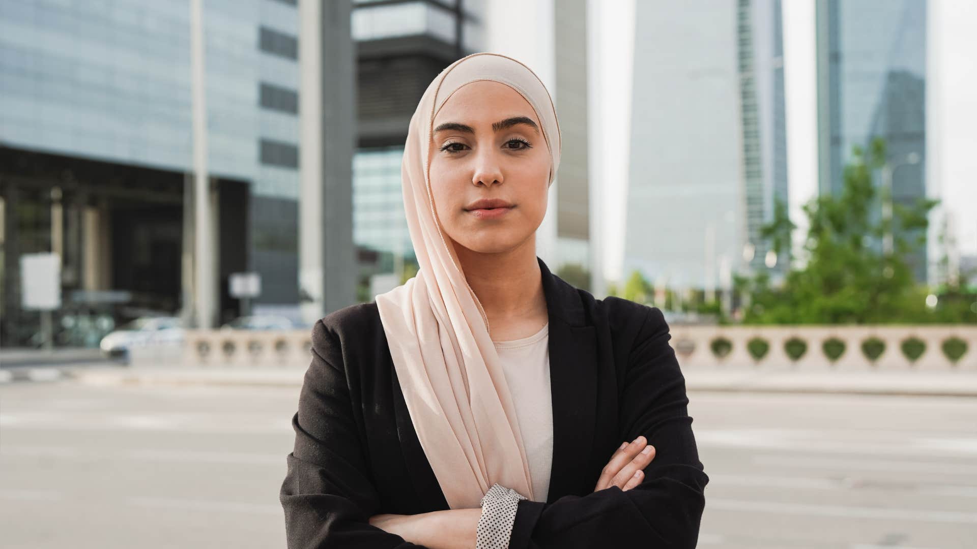 young woman with arms crossed standing outside