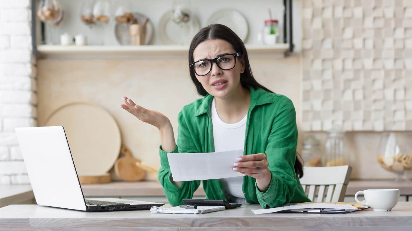 Woman who is experiencing lifestyle creep looking at her bank statement