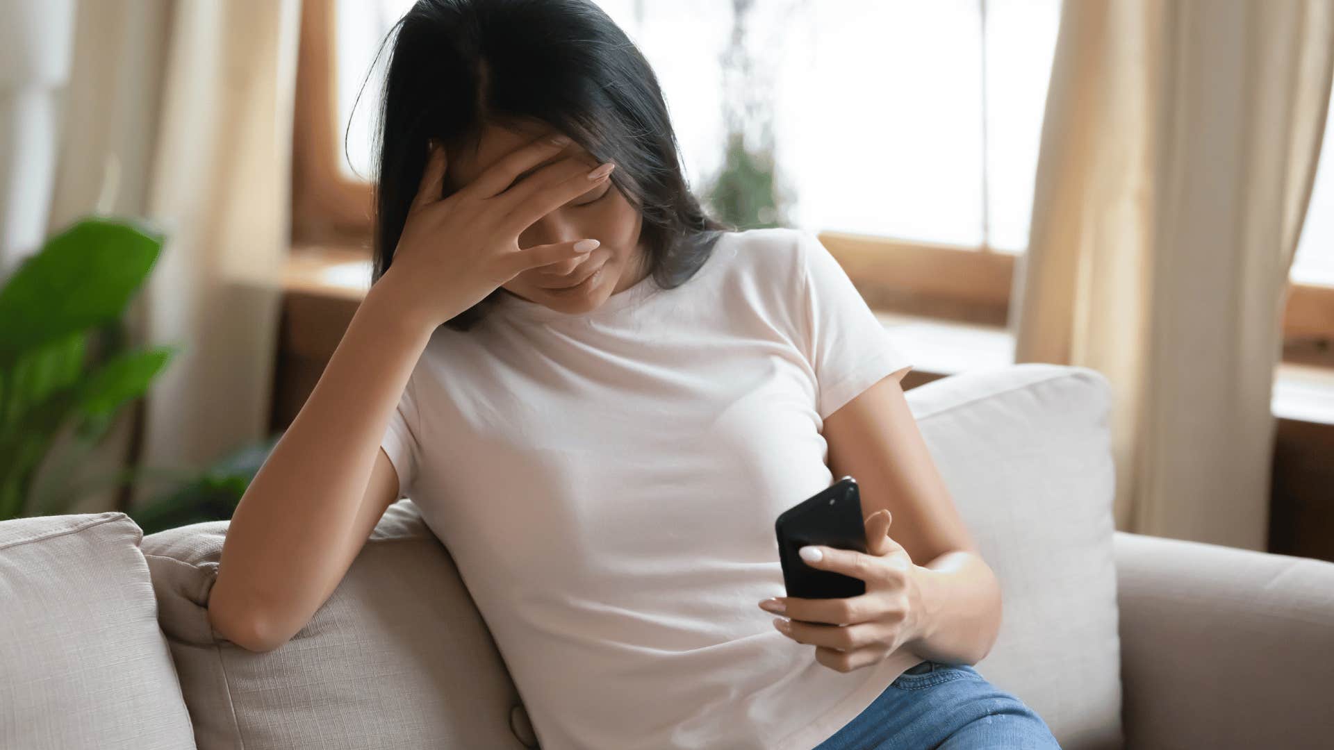 upset woman looking at phone