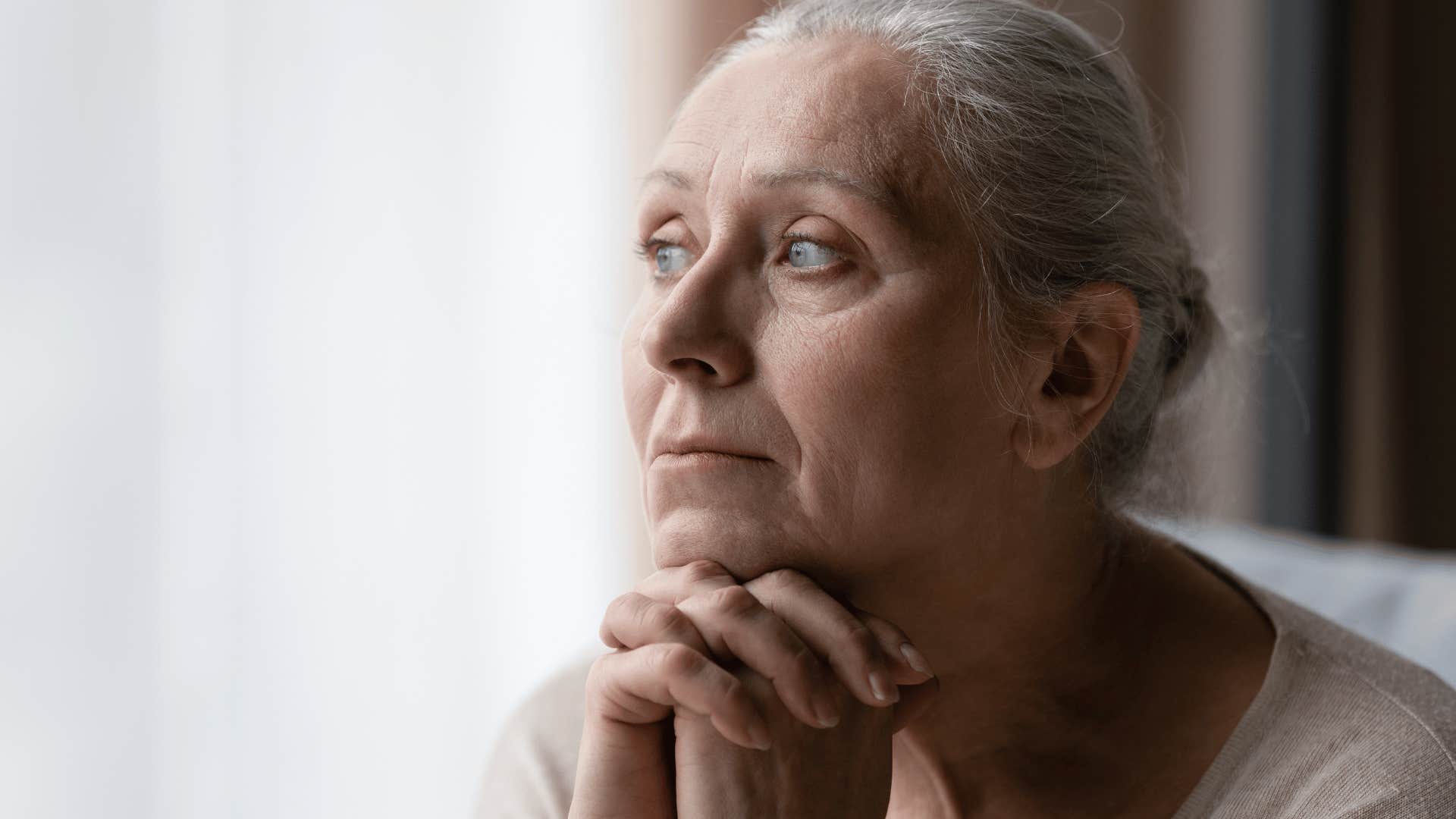 older woman looking out window