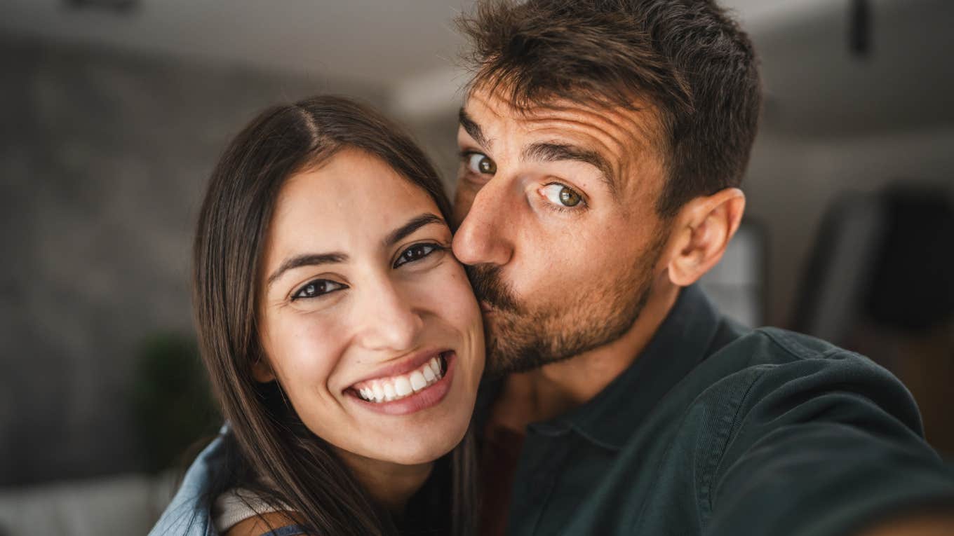 loving man kissing smiling woman's cheek