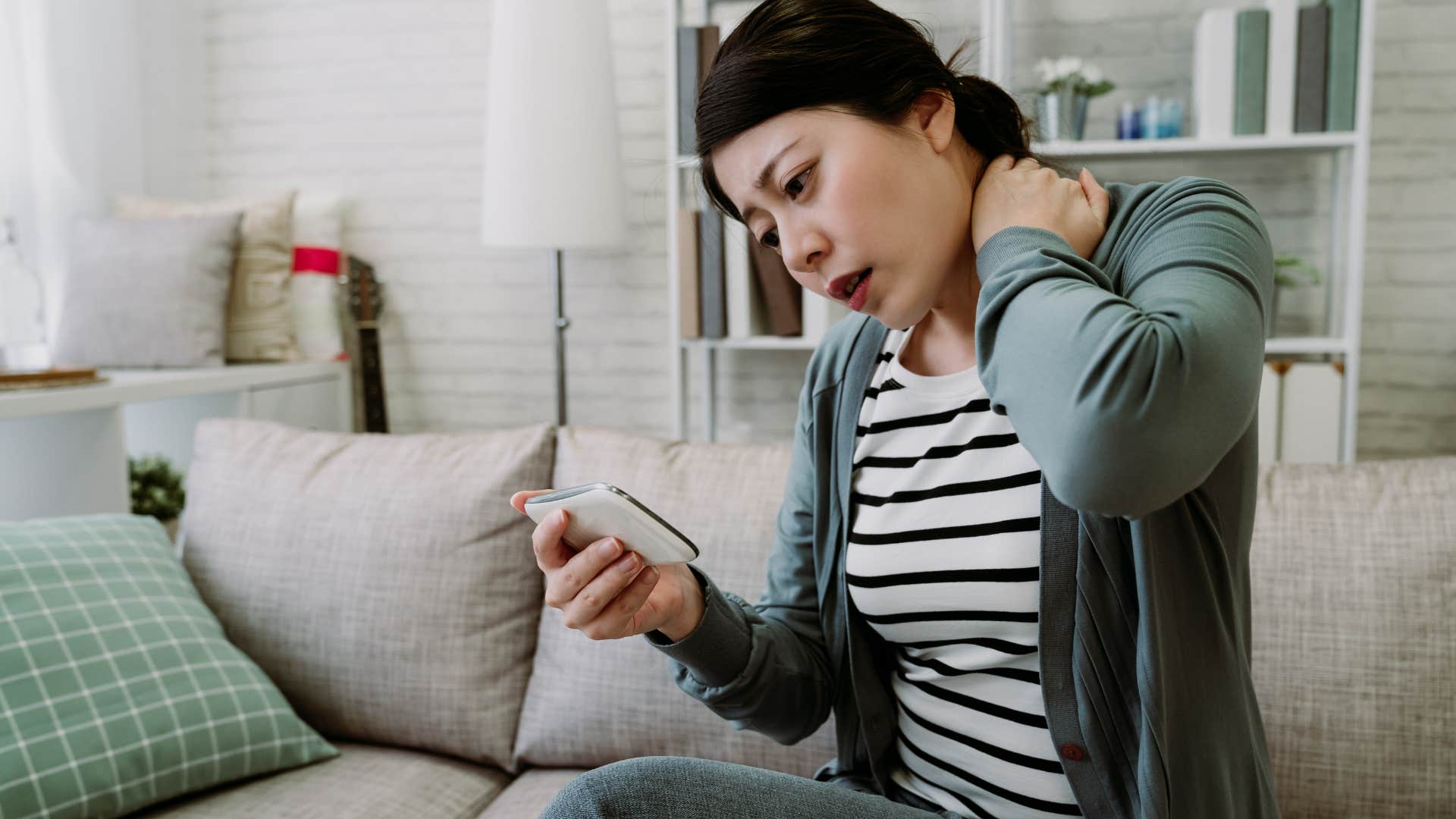 slouching woman holding her neck