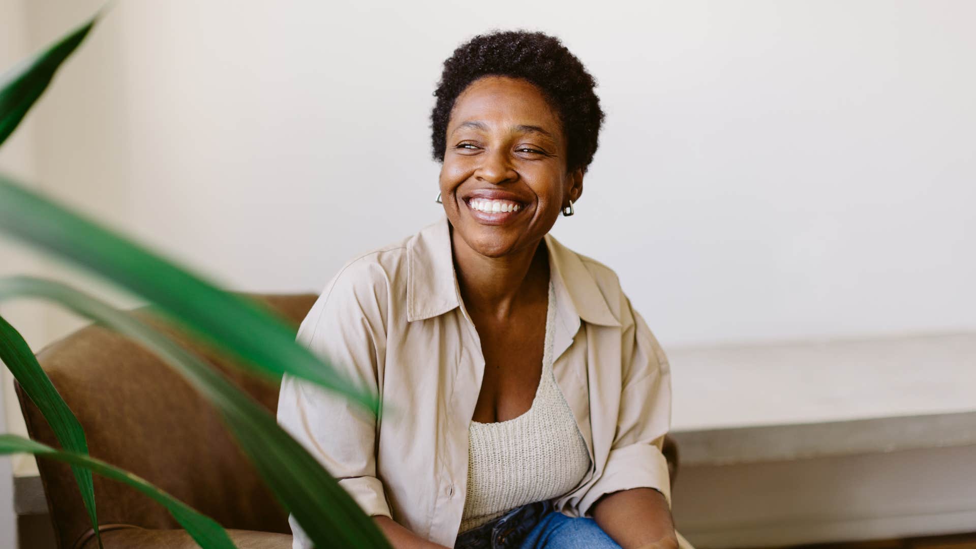 woman sits on a couch in her home