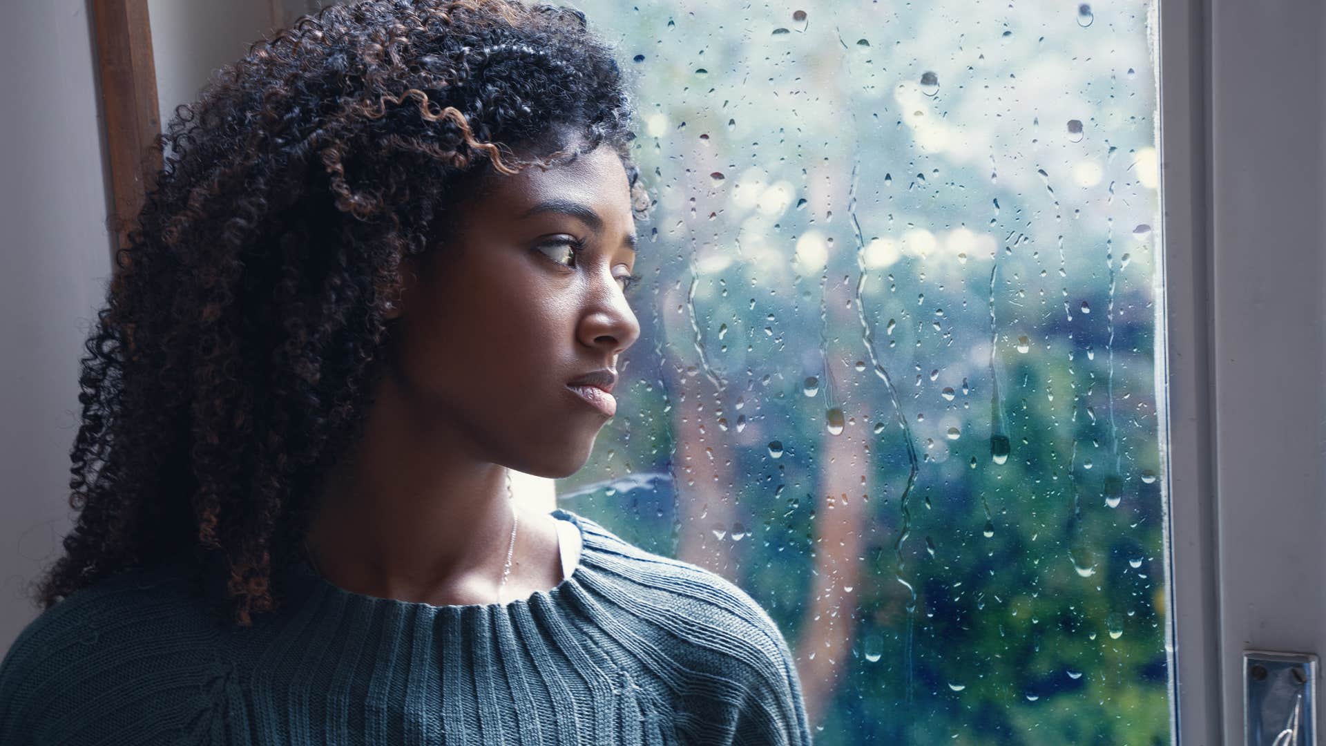 Sad woman looking out a window.