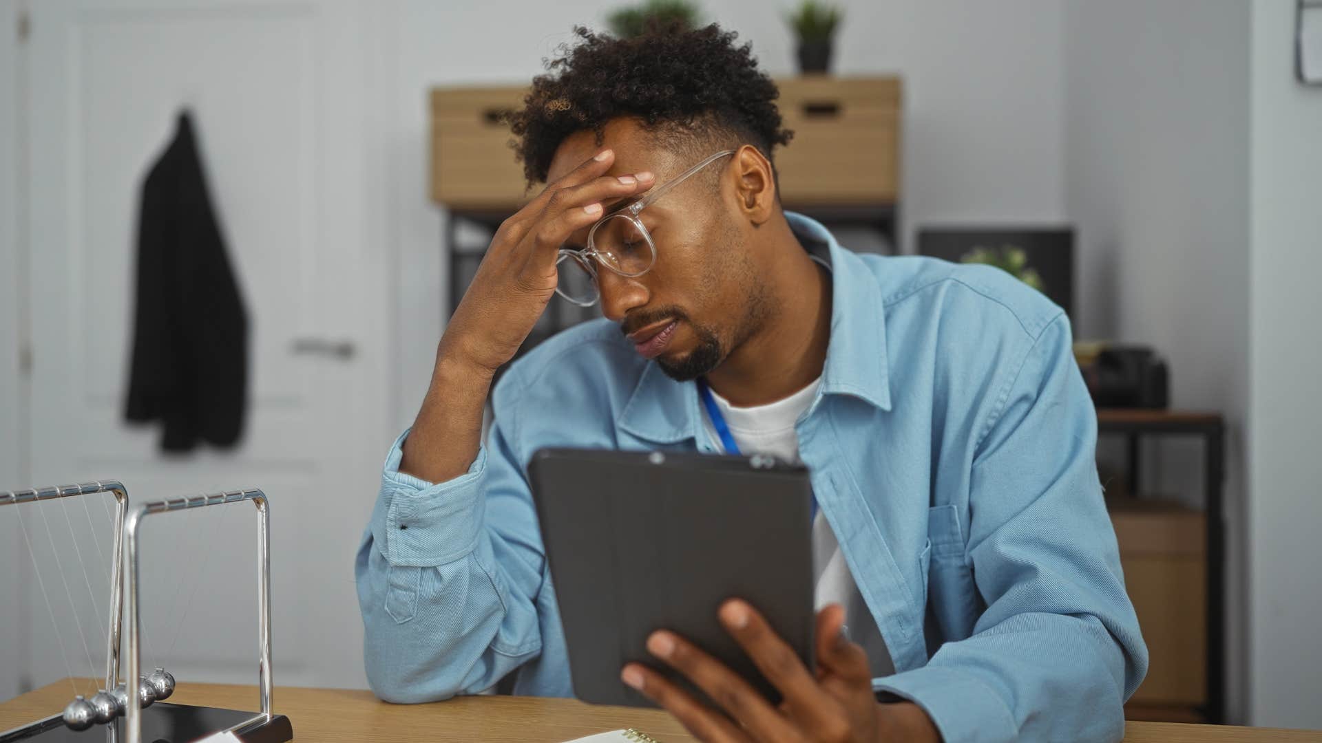 Man clutching his head while working.