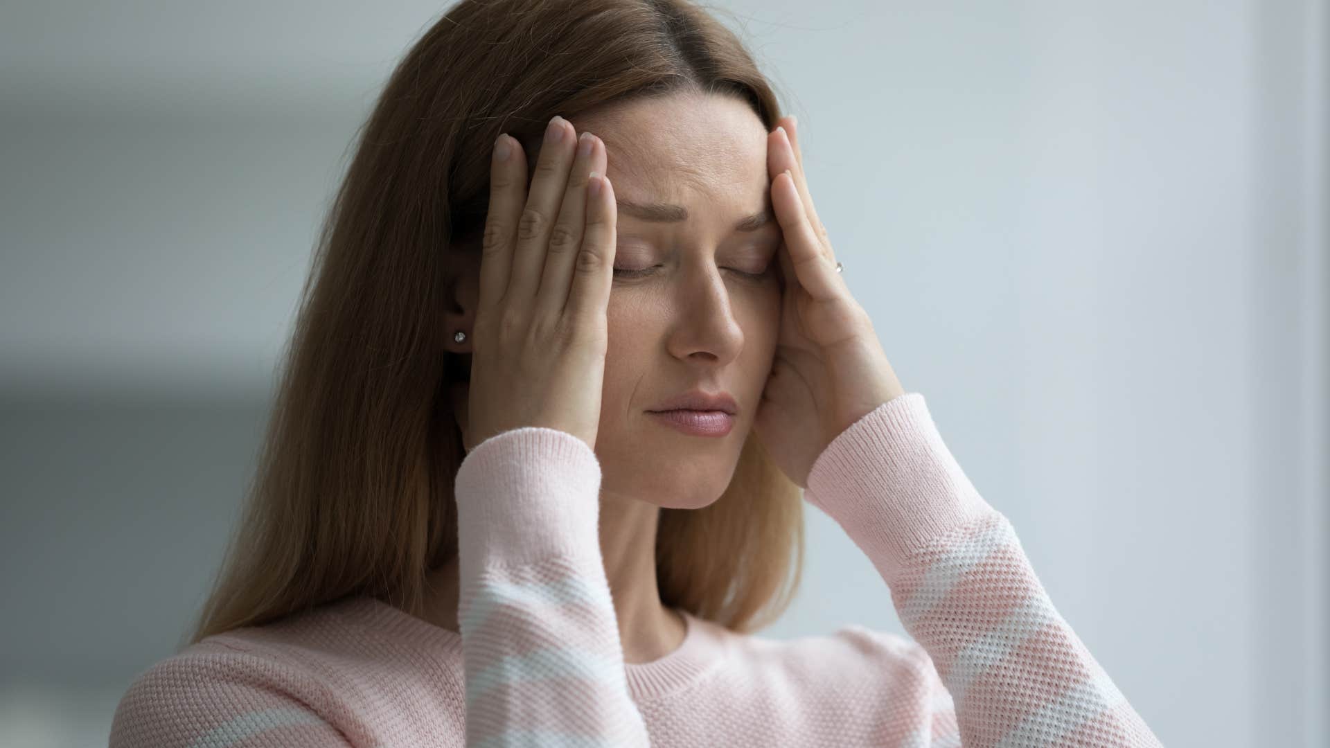 Tired woman holding her head in her hands.