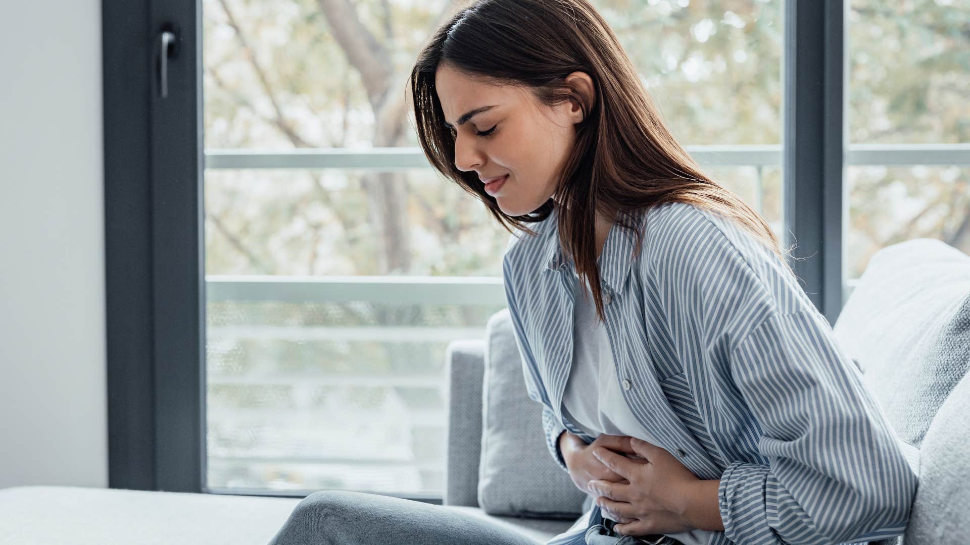 Upset woman holding her stomach.