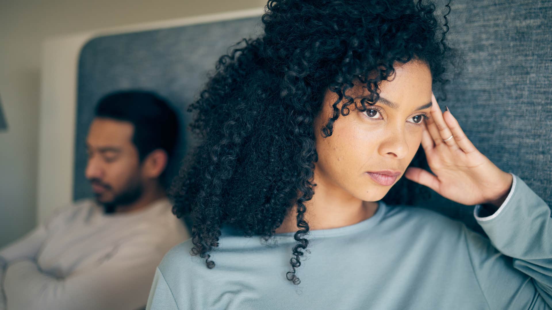 Woman holding her head looking away from her husband.