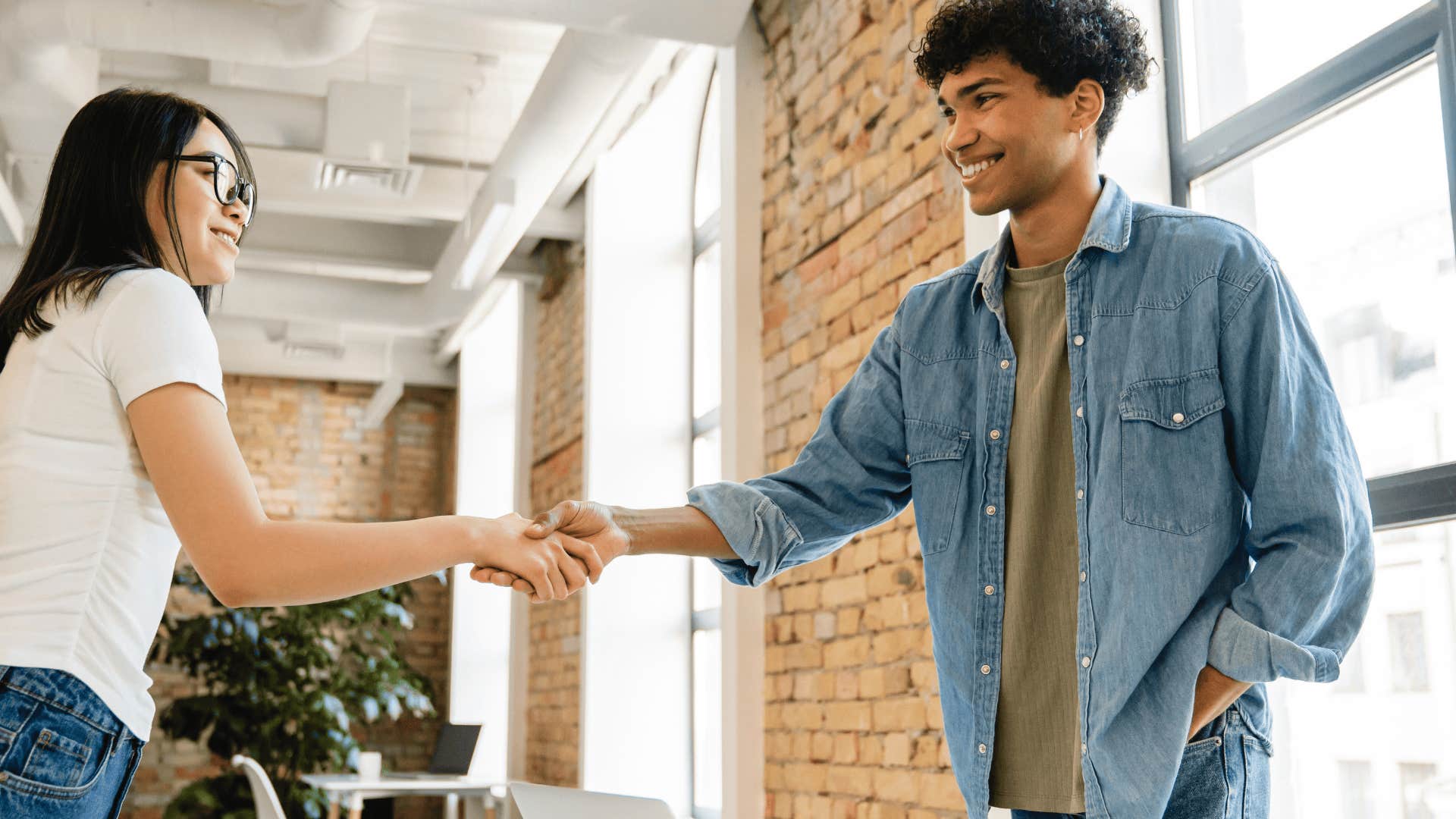 weak hand shake between young adults at a cafe