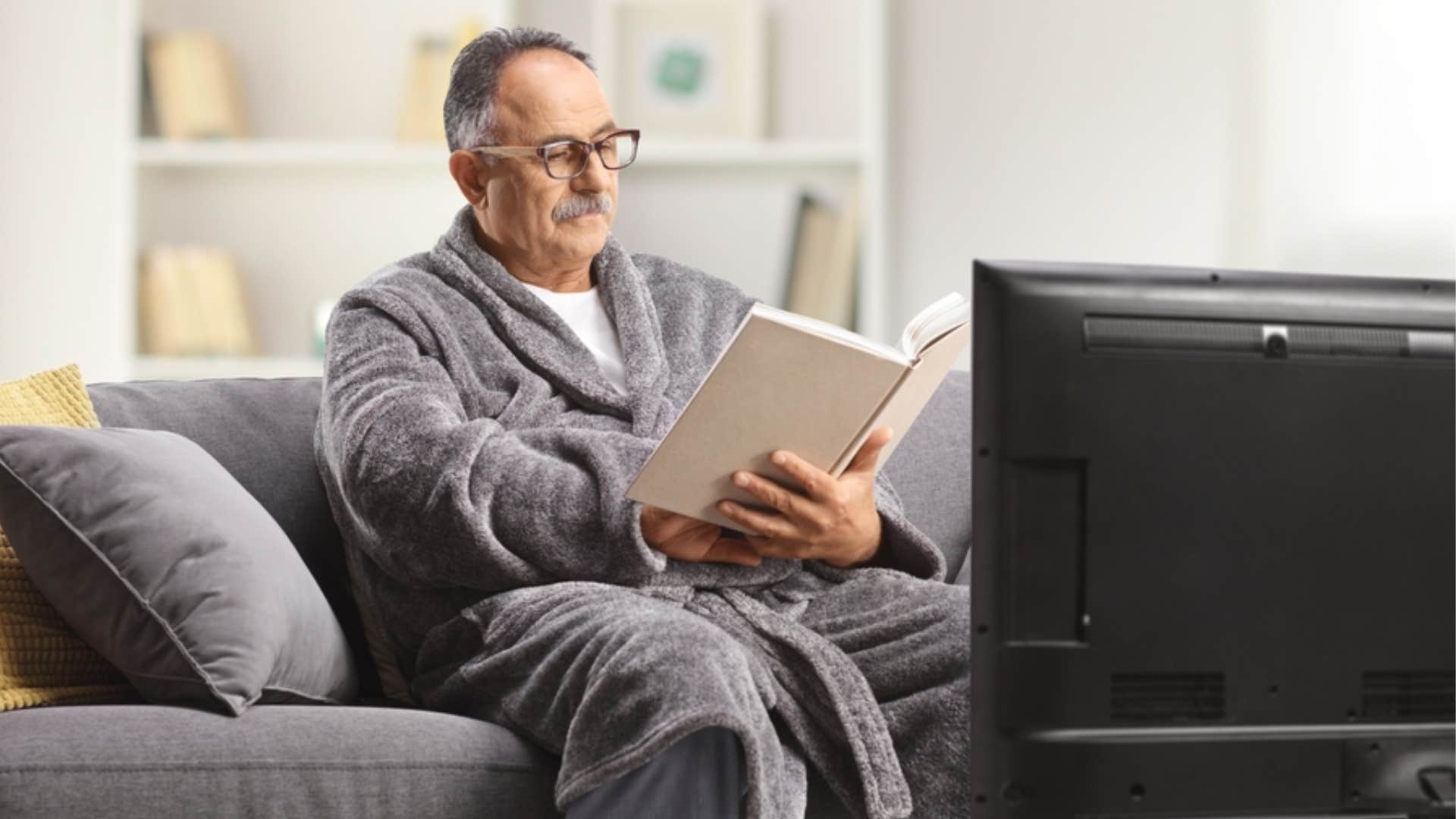 man reading instead of watching television