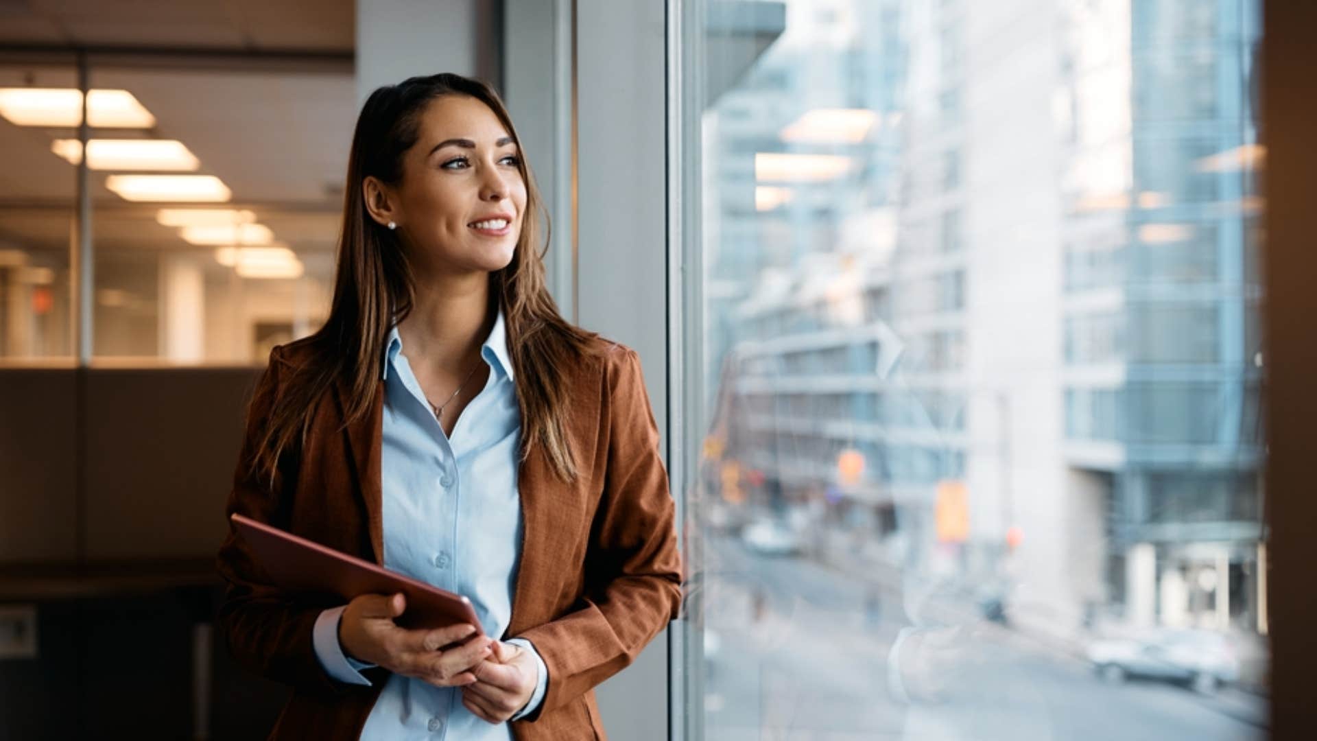 successful woman looking out the window