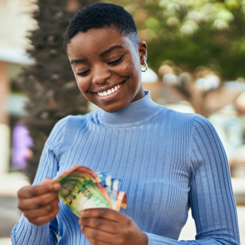 woman counting money while traveling 