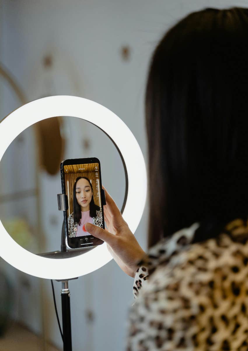 woman filming herself on her phone for social media