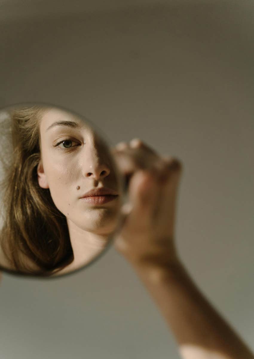 woman looking in mirror not happy with her image