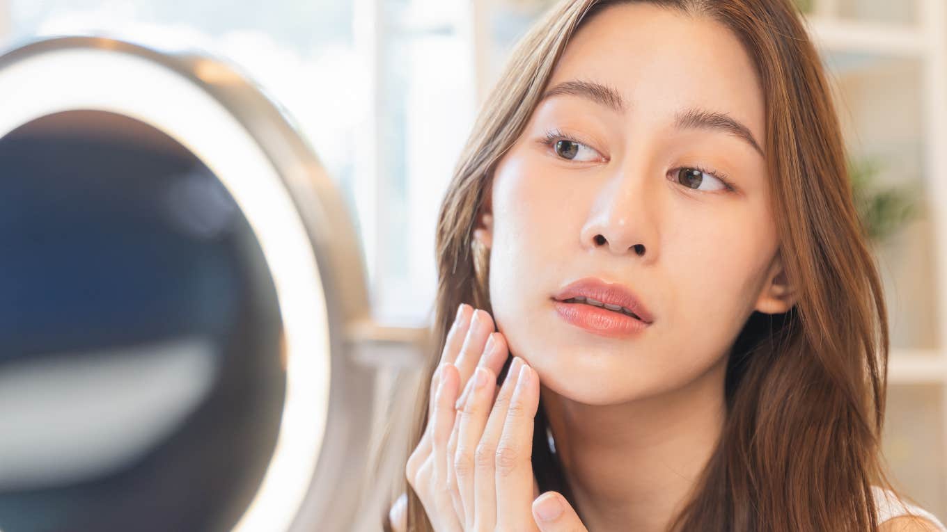 woman scrutinizing herself in the mirror