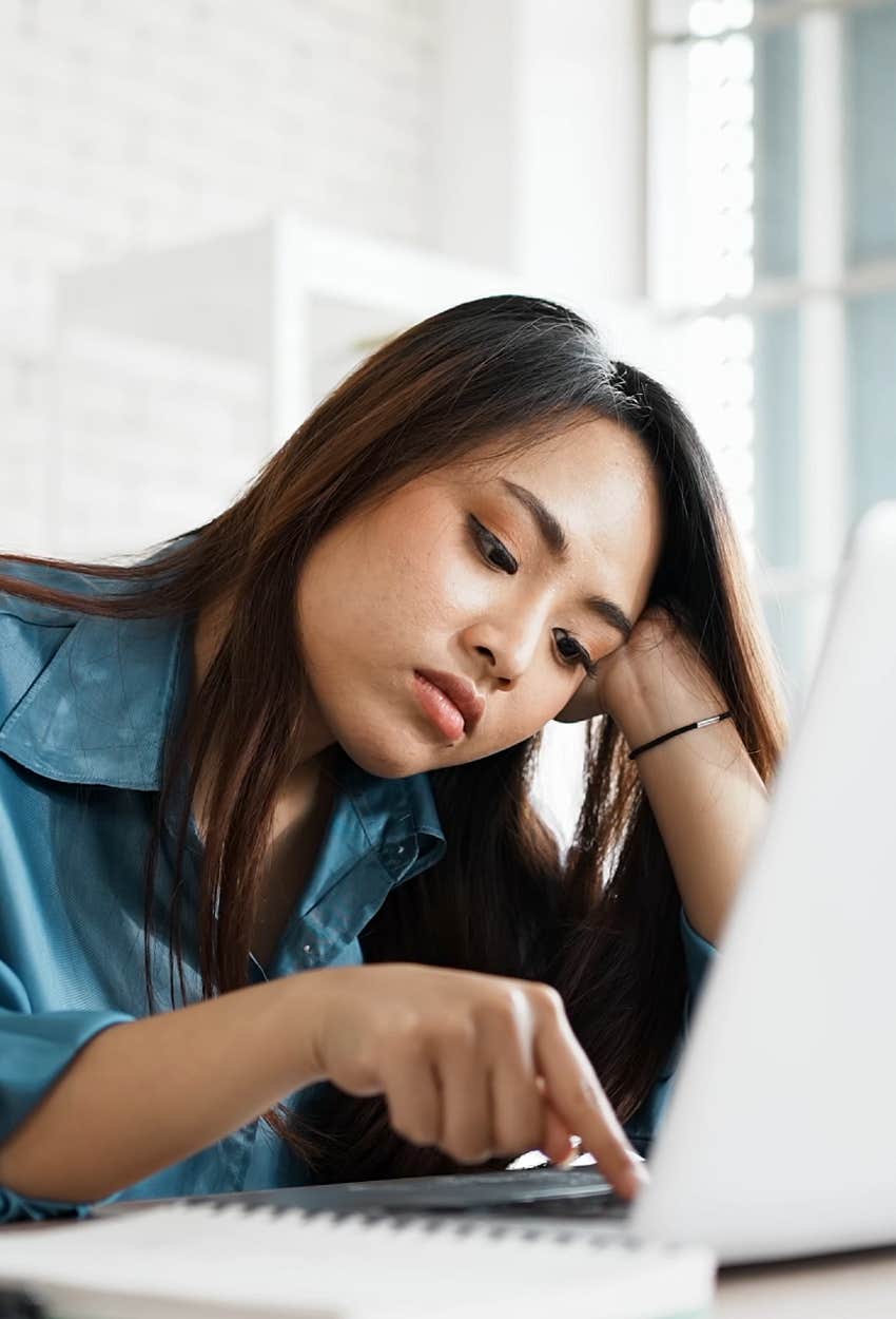 Bored woman faking productivity at the office