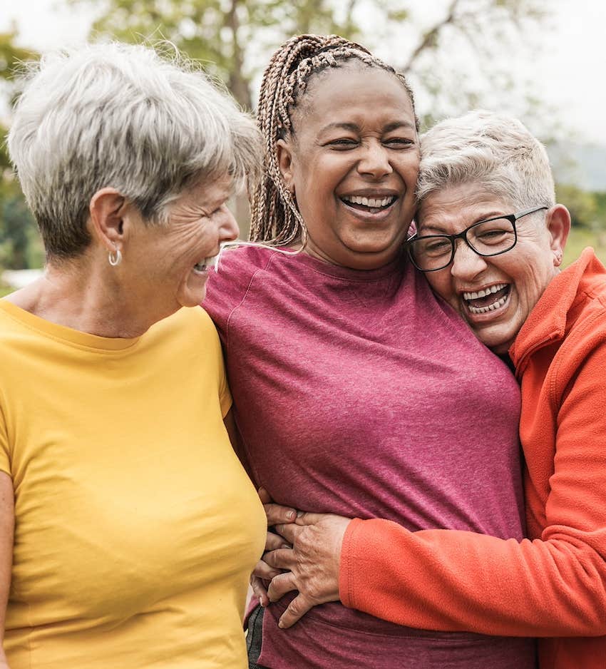 Three smiling woman support each other emotionally