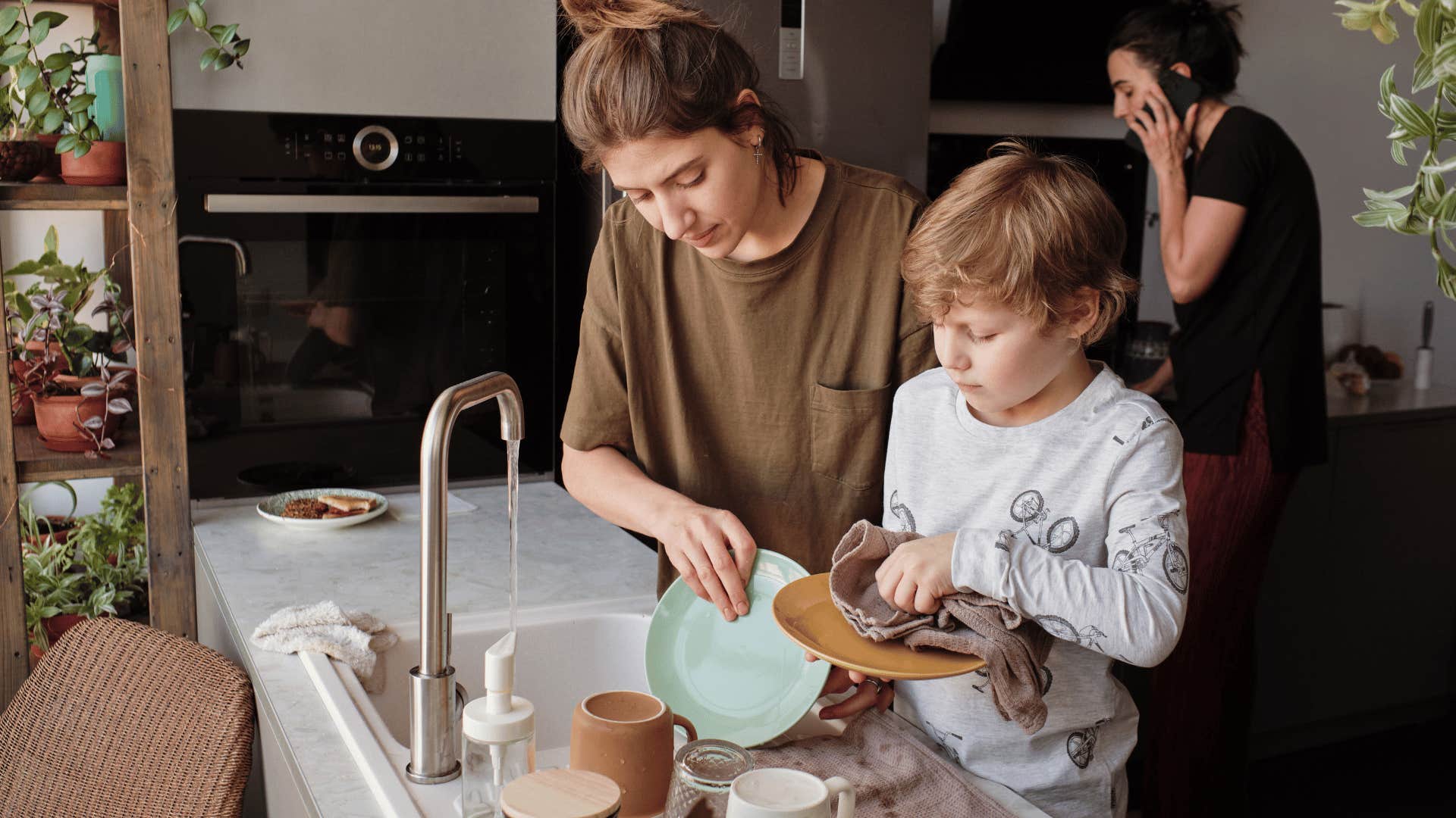 boy helping his mom do the dishes