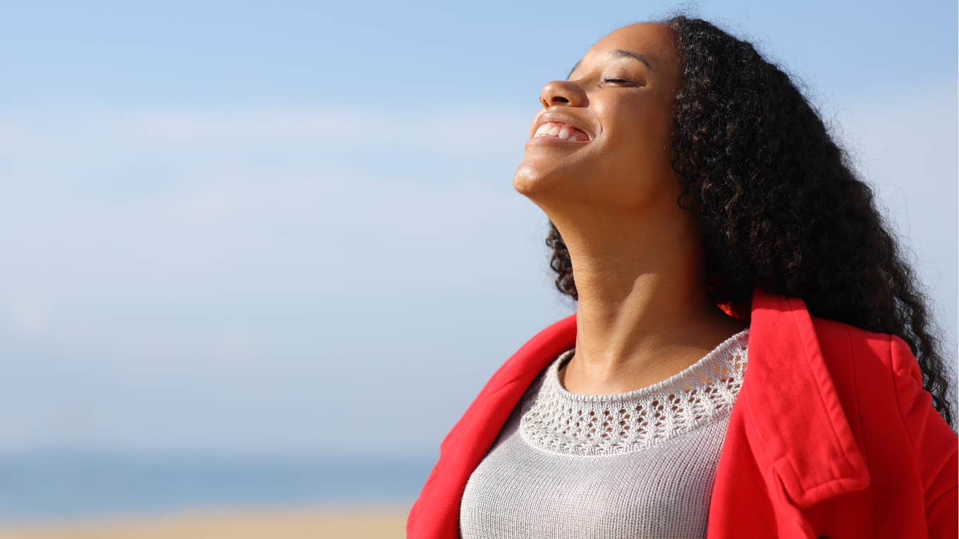 Woman smiling with her eyes closed in the sunshine