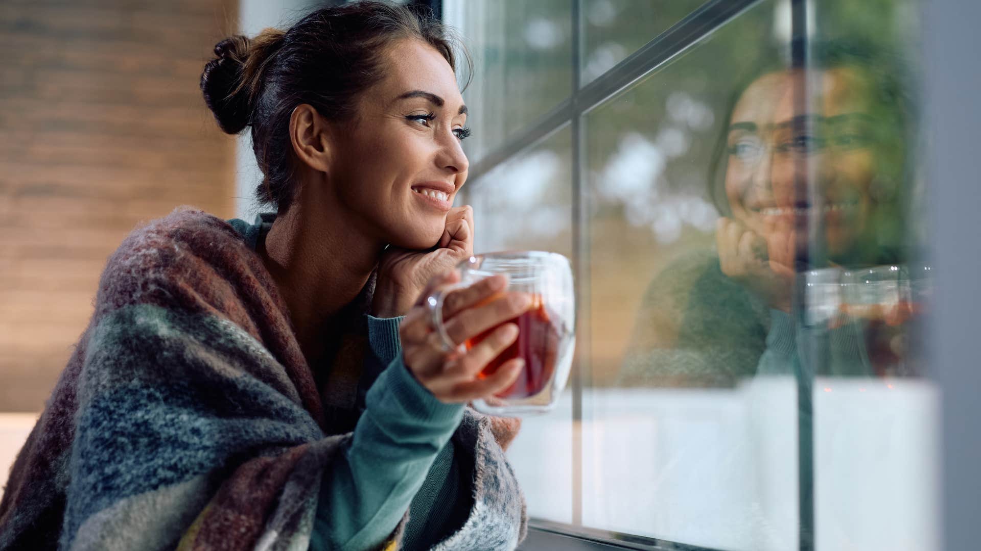 Woman smiling and people-watching from her window