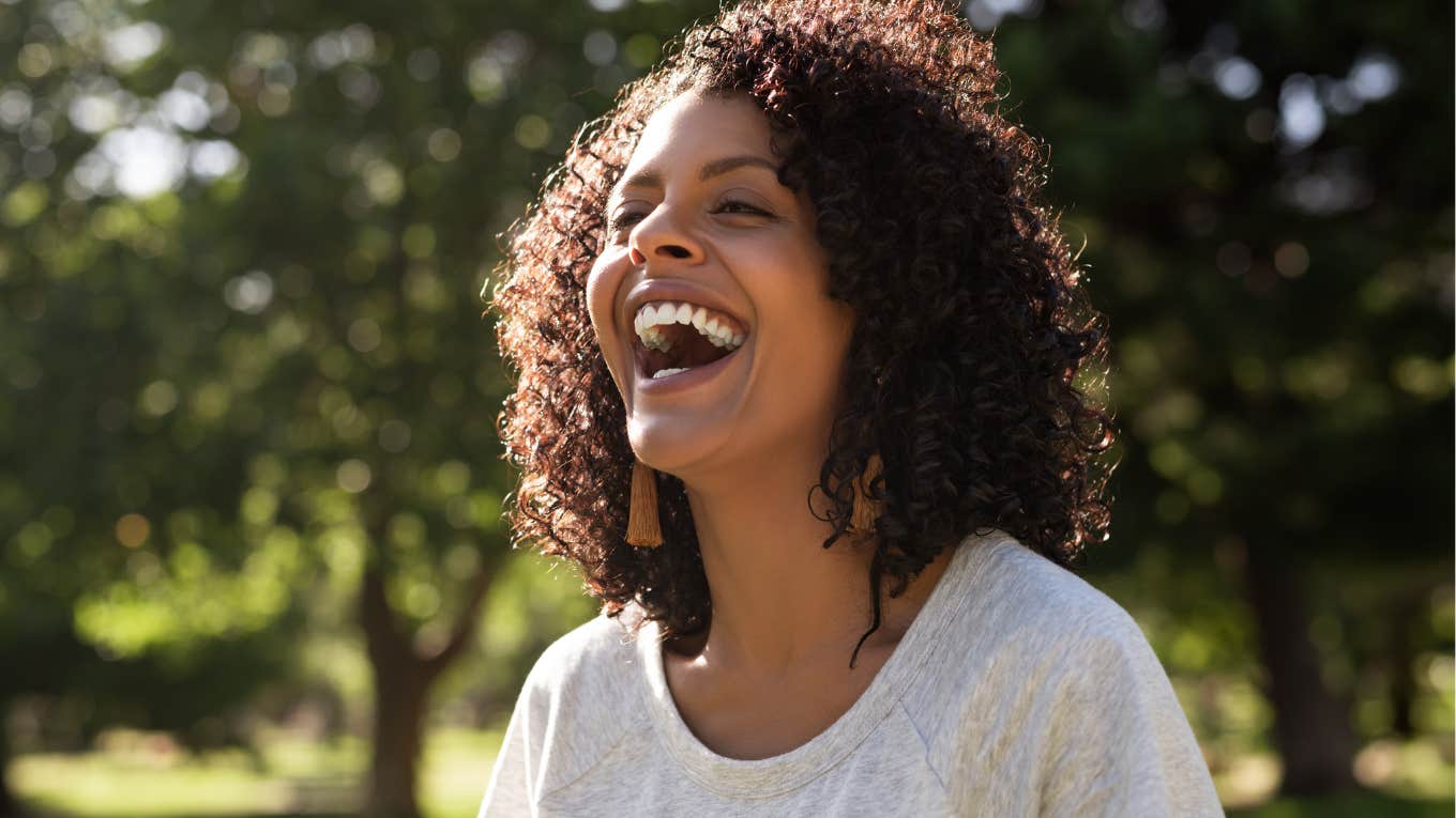 Woman smiling and laughing outside.